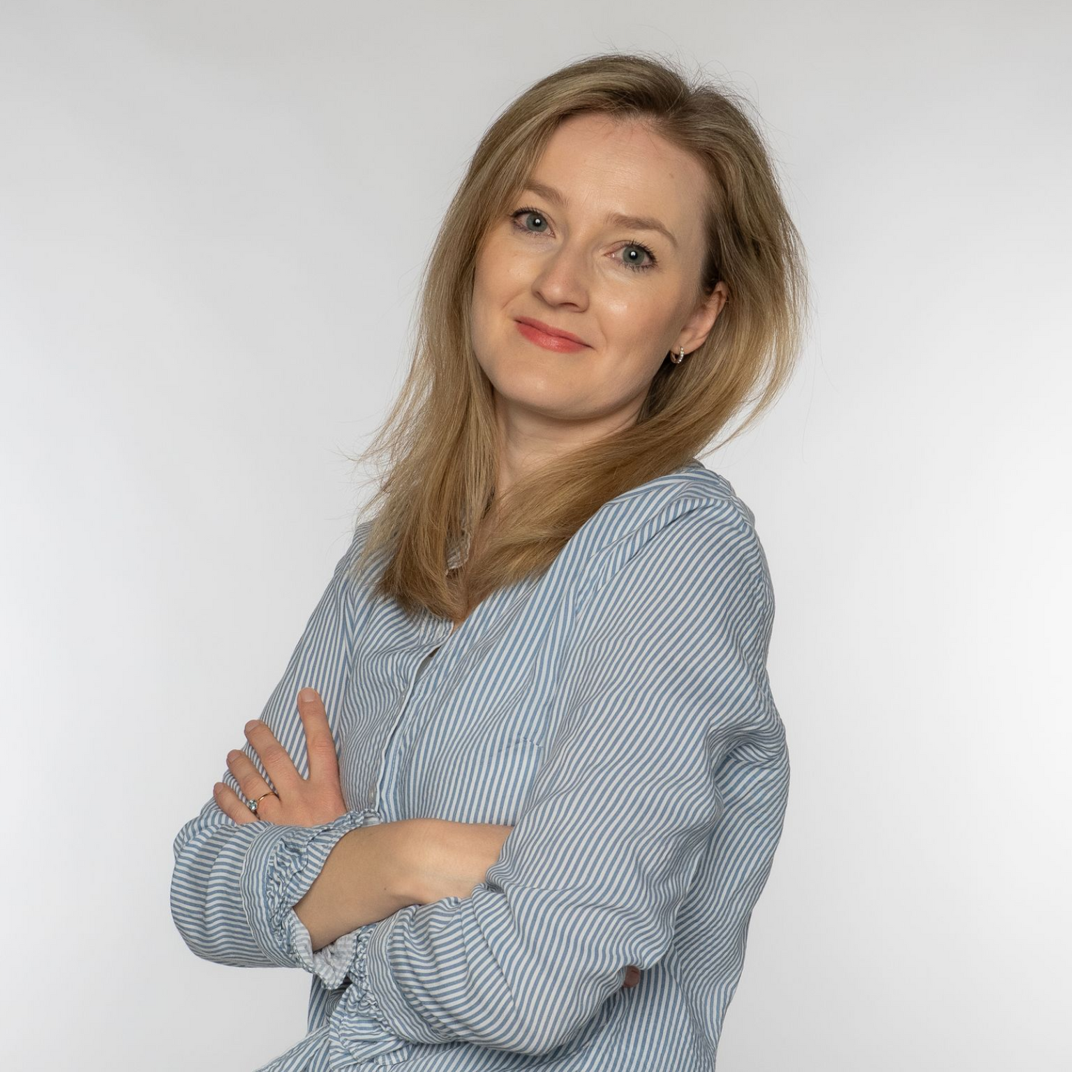 Nachhilfelehrerin Amelie steht mit verschränkten Armen da und lächelt in die Kamera.