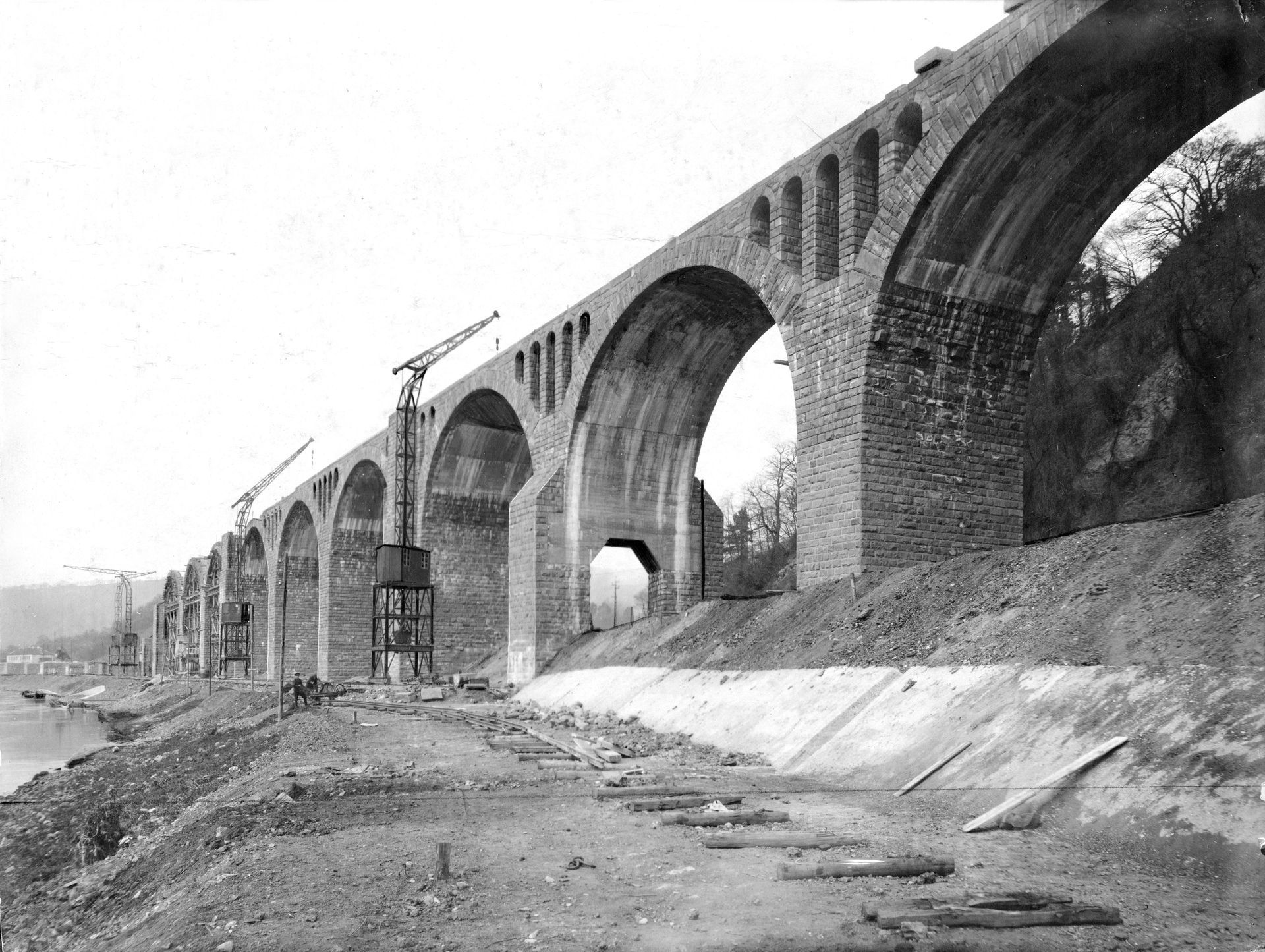 Bestandteil der militär-strategischen Bahnlinie Ehrang – Neuwied ist die Quinter Talbrücke, auch genannt das „Quinter Viadukt“. Die formschöne Brücke wurde als einer der wenigen Bauten der sogenannten rechtsufrigen Moselbahn fertiggestellt. Über eine Länge von 500 Metern würden die Güterzüge über das Viadukt mit einer Steigung von 1:150 ab Ehrang über das 3. und 4. Gleis in Richtung Bengel geführt. Dabei hätte man den Ortsteil Ehrang und den Meulenwaldtunnel umfahren. Die Aufnahme entsteht während des Baus im Frühjahr 1920. Aufnahme: Ivar Arstadt, Slg. Martin Kreckler Bestandteil der militär-strategischen Bahnlinie Ehrang – Neuwied ist die Quinter Talbrücke, auch genannt das „Quinter Viadukt“. Die formschöne Brücke wurde als einer der wenigen Bauten der sogenannten rechtsufrigen Moselbahn fertiggestellt. Über eine Länge von 500 Metern würden die Güterzüge über das Viadukt mit einer Steigung von 1:150 ab Ehrang über das 3. und 4. Gleis in Richtung Bengel geführt. Dabei hätte man den Ortsteil Ehrang und den Meulenwaldtunnel umfahren. Die Aufnahme entsteht während des Baus im Frühjahr 1920.
Aufnahme: Ivar Arstadt, Slg. Martin Kreckler