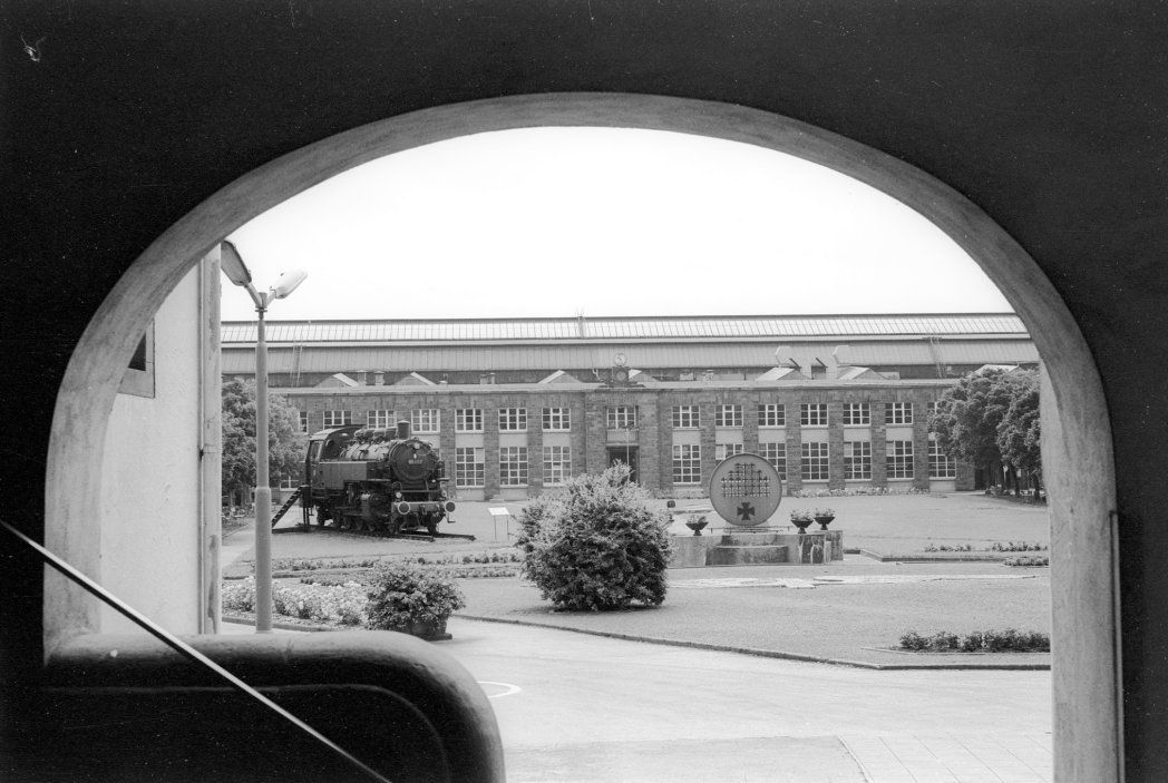 Blick vom Verwaltungsgebäude auf die Richthalle am 1. Juli 1977. Als Denkmal wurde 1974 die 86 456 aufgestellt. 1985 ist die Lokomotive wieder für Sonderfahrten aufbereitet und auf richtige Gleise gestellt worden. Aufnahme Martin Kreckler