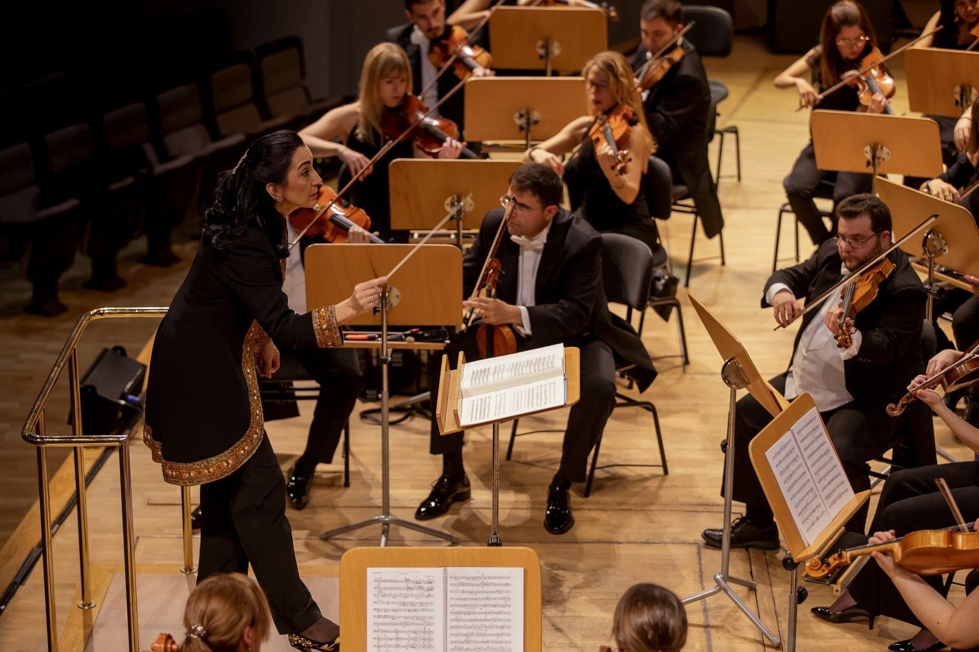 Silvia Sanz Torre estudió guitarra, piano y…dirección de orquesta en un tiempo, los años 80 del siglo anterior, en el que resultaba “inaudito” que las mujeres tomaran la batuta. Dato que, por sí solo, revela una vocación vigorosa y una voluntad nervuda, capaz de transformar en tangibles los sueños que el entorno juzga quiméricos. Hoy —gracias a ella, entre otras pioneras— las estudiantes españolas de música saben que la dirección orquestal es también un espacio de mujeres. Desde hace cinco lustros, Silvia Sanz es fundadora y directora titular del Grupo Talía y de todas sus formaciones musicales: Orquesta Metropolitana de Madrid y Coro Talía, con temporada estable de conciertos en el Auditorio Nacional de Música, Madrid Youth Orchestra, Orquesta Infantil Jonsui y Coro Talía Mini. El poliédrico Grupo Talía es producto de la creatividad —en el sentido más pleno del término— de Silvia Sanz. Más allá de una formidable profesional que ha dirigido orquestas nacionales e internacionales, Sanz es una prolífica constructora de oportunidades de crecimiento para otros: es una propagadora de cultura, empeñada en formar a los músicos y a los públicos del porvenir. De ahí que también desarrolle una mirífica actividad divulgadora a través de conciertos, cuyo fin es enseñar a personas —sin distinción de edad y nivel educativo— a escuchar, sentir, apreciar y disfrutar la música. Otra de sus iniciativas hacedoras de futuro es el Encuentro Orquestal Sinfónico de Alba de Tormes, un campamento orquestal en verano dirigido a instrumentistas desde 9 a 13 años, que viene celebrándose desde 2011. No es de extrañar, pues, que en 2017, fuese galardonada en los VII Premios Solidarios a la Igualdad MDE en la categoría de Mujeres que cambian el mundo, y que en dos ocasiones haya integrado la lista Top100 mujeres líderes en España de Mujeres & Cia. Su labor generatriz de nuevos músicos y públicos también la ha desempeñado fuera de España, en América Latina y África… La Asamblea Legislativa de El Salvador le concedió una distinción por su “ejemplo de participación de la mujer en espacios que contribuyen a erradicar desigualdades en todo el mundo”. Y en 2012, en Etiopía, puso en marcha y dirigió los conciertos de la Yared School of Music, única escuela de música del país y que se encontraba inactiva desde hacía cuatro décadas. La música es para ella imprescindible: una inversión en futuro, una apuesta inequívoca en valores humanos. Los suyos nos han cautivado y por eso hemos querido entrevistarla…
