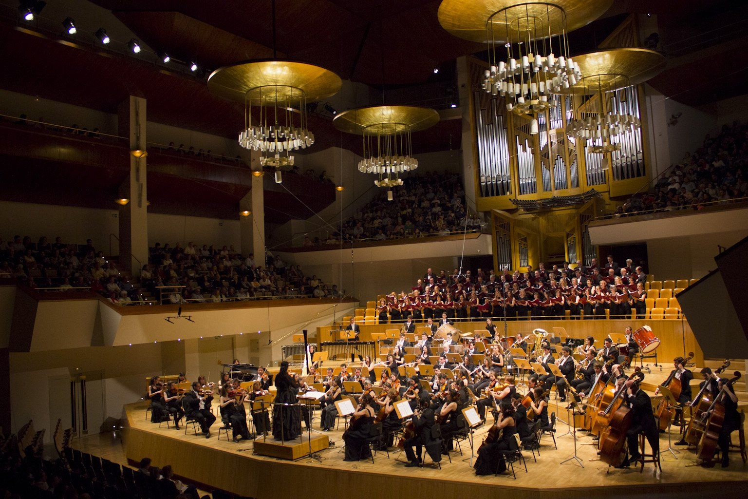 Silvia Sanz Torre estudió guitarra, piano y…dirección de orquesta en un tiempo, los años 80 del siglo anterior, en el que resultaba “inaudito” que las mujeres tomaran la batuta. Dato que, por sí solo, revela una vocación vigorosa y una voluntad nervuda, capaz de transformar en tangibles los sueños que el entorno juzga quiméricos. Hoy —gracias a ella, entre otras pioneras— las estudiantes españolas de música saben que la dirección orquestal es también un espacio de mujeres. Desde hace cinco lustros, Silvia Sanz es fundadora y directora titular del Grupo Talía y de todas sus formaciones musicales: Orquesta Metropolitana de Madrid y Coro Talía, con temporada estable de conciertos en el Auditorio Nacional de Música, Madrid Youth Orchestra, Orquesta Infantil Jonsui y Coro Talía Mini. El poliédrico Grupo Talía es producto de la creatividad —en el sentido más pleno del término— de Silvia Sanz. Más allá de una formidable profesional que ha dirigido orquestas nacionales e internacionales, Sanz es una prolífica constructora de oportunidades de crecimiento para otros: es una propagadora de cultura, empeñada en formar a los músicos y a los públicos del porvenir. De ahí que también desarrolle una mirífica actividad divulgadora a través de conciertos, cuyo fin es enseñar a personas —sin distinción de edad y nivel educativo— a escuchar, sentir, apreciar y disfrutar la música. Otra de sus iniciativas hacedoras de futuro es el Encuentro Orquestal Sinfónico de Alba de Tormes, un campamento orquestal en verano dirigido a instrumentistas desde 9 a 13 años, que viene celebrándose desde 2011. No es de extrañar, pues, que en 2017, fuese galardonada en los VII Premios Solidarios a la Igualdad MDE en la categoría de Mujeres que cambian el mundo, y que en dos ocasiones haya integrado la lista Top100 mujeres líderes en España de Mujeres & Cia. Su labor generatriz de nuevos músicos y públicos también la ha desempeñado fuera de España, en América Latina y África… La Asamblea Legislativa de El Salvador le concedió una distinción por su “ejemplo de participación de la mujer en espacios que contribuyen a erradicar desigualdades en todo el mundo”. Y en 2012, en Etiopía, puso en marcha y dirigió los conciertos de la Yared School of Music, única escuela de música del país y que se encontraba inactiva desde hacía cuatro décadas. La música es para ella imprescindible: una inversión en futuro, una apuesta inequívoca en valores humanos. Los suyos nos han cautivado y por eso hemos querido entrevistarla… Silvia Sanz Torre estudió guitarra, piano y…dirección de orquesta en un tiempo, los años 80 del siglo anterior, en el que resultaba “inaudito” que las mujeres tomaran la batuta. Dato que, por sí solo, revela una vocación vigorosa y una voluntad nervuda, capaz de transformar en tangibles los sueños que el entorno juzga quiméricos. Hoy —gracias a ella, entre otras pioneras— las estudiantes españolas de música saben que la dirección orquestal es también un espacio de mujeres. Desde hace cinco lustros, Silvia Sanz es fundadora y directora titular del Grupo Talía y de todas sus formaciones musicales: Orquesta Metropolitana de Madrid y Coro Talía, con temporada estable de conciertos en el Auditorio Nacional de Música, Madrid Youth Orchestra, Orquesta Infantil Jonsui y Coro Talía Mini. El poliédrico Grupo Talía es producto de la creatividad —en el sentido más pleno del término— de Silvia Sanz. Más allá de una formidable profesional que ha dirigido orquestas nacionales e internacionales, Sanz es una prolífica constructora de oportunidades de crecimiento para otros: es una propagadora de cultura, empeñada en formar a los músicos y a los públicos del porvenir. De ahí que también desarrolle una mirífica actividad divulgadora a través de conciertos, cuyo fin es enseñar a personas —sin distinción de edad y nivel educativo— a escuchar, sentir, apreciar y disfrutar la música. Otra de sus iniciativas hacedoras de futuro es el Encuentro Orquestal Sinfónico de Alba de Tormes, un campamento orquestal en verano dirigido a instrumentistas desde 9 a 13 años, que viene celebrándose desde 2011. No es de extrañar, pues, que en 2017, fuese galardonada en los VII Premios Solidarios a la Igualdad MDE en la categoría de Mujeres que cambian el mundo, y que en dos ocasiones haya integrado la lista Top100 mujeres líderes en España de Mujeres & Cia. Su labor generatriz de nuevos músicos y públicos también la ha desempeñado fuera de España, en América Latina y África… La Asamblea Legislativa de El Salvador le concedió una distinción por su “ejemplo de participación de la mujer en espacios que contribuyen a erradicar desigualdades en todo el mundo”. Y en 2012, en Etiopía, puso en marcha y dirigió los conciertos de la Yared School of Music, única escuela de música del país y que se encontraba inactiva desde hacía cuatro décadas. La música es para ella imprescindible: una inversión en futuro, una apuesta inequívoca en valores humanos. Los suyos nos han cautivado y por eso hemos querido entrevistarla…