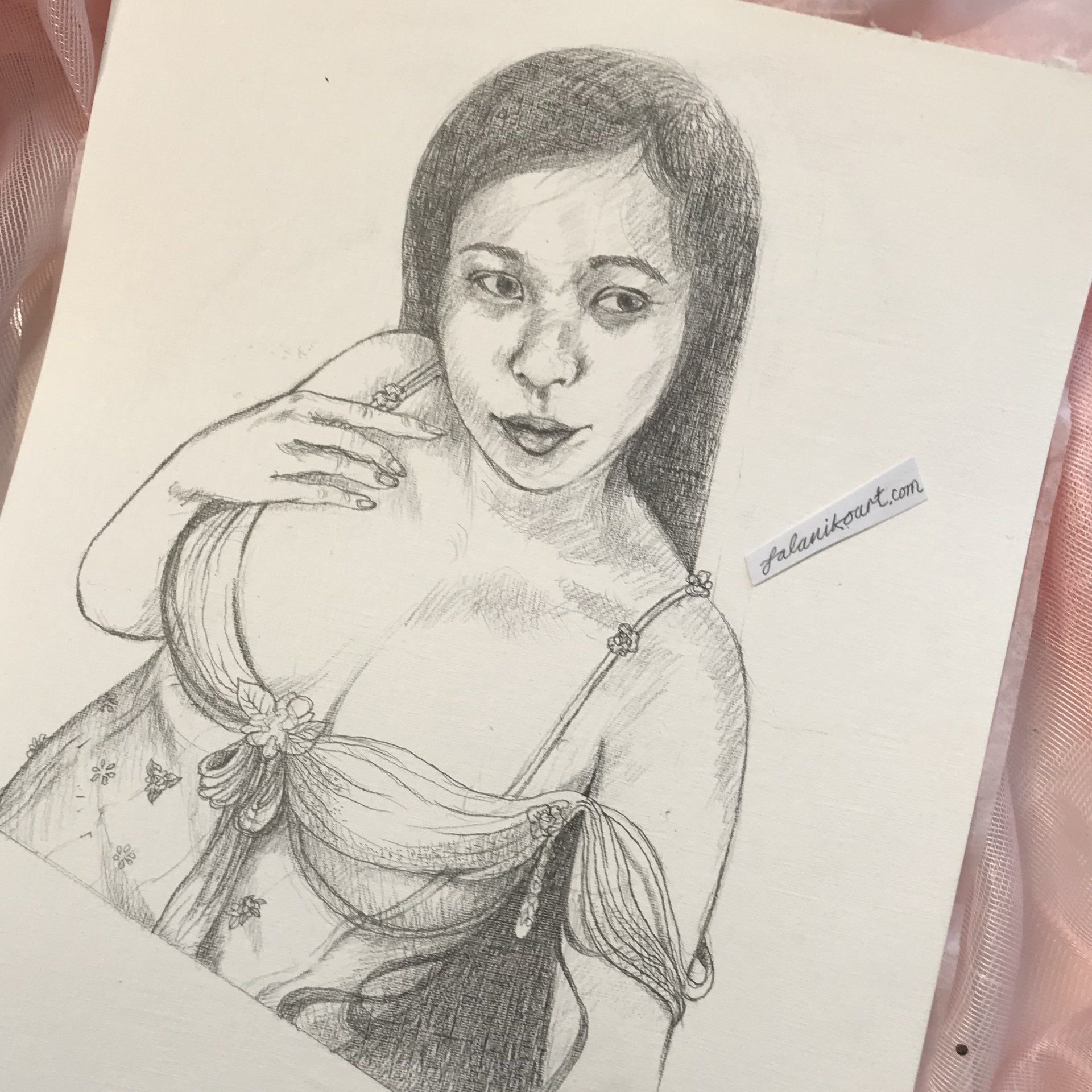 A graphite sketch of a woman in her thirties with long black hair. She is reclining, wearing a lacy bodice with silky soft arm straps falling off her shoulder