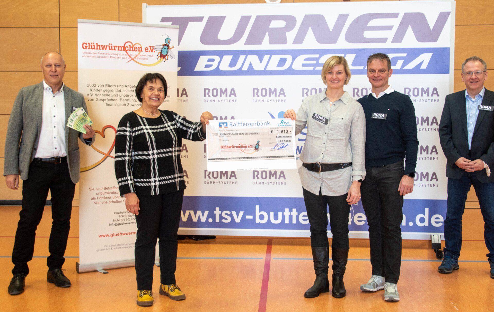 Auf dem Bild zu sehen- von links nach rechts - Hr. Klemens Wölfel , Geschäftsführer der Firma Romakowski, Frau Rosmarie Schweyer, Vorsitzende von Glühwürmchen e.V. - Übergeben wird der Scheck von Katrin und Helmut Kehl. Im Hintergrund Alfred Ebert, Vorstand des TSV