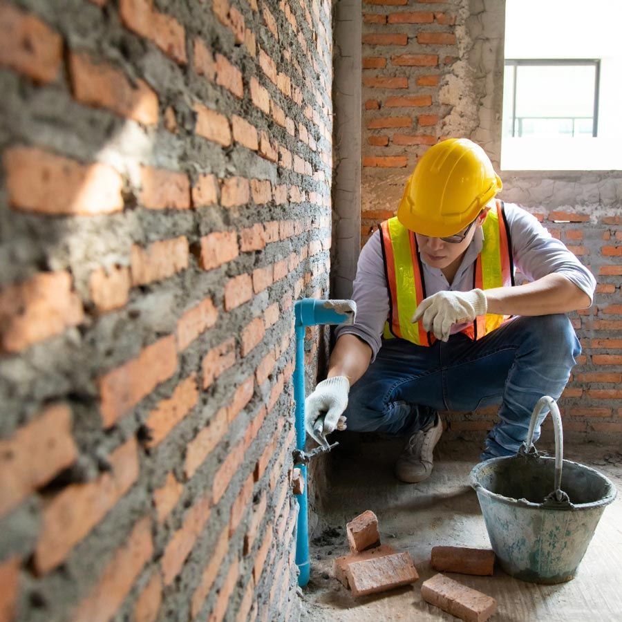 Erfahrener Maurer bei der präzisen Steinsetzung für eine neue Gartenmauer in Lemgo – MW-Bau Handwerkskunst.