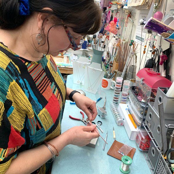 Photograph of Brighton Artist Troy Ohlson creating hand crochet silver jewellery at her studio workbench