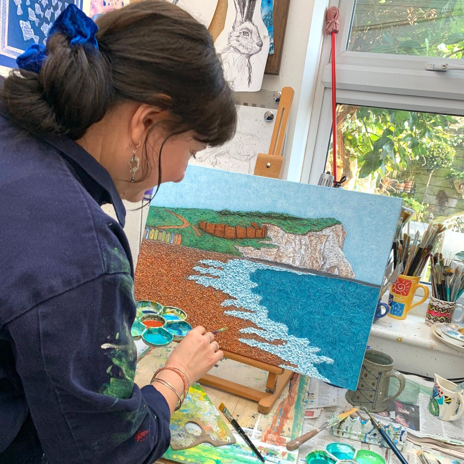 Brighton Artist Troy Ohlson painting in her studio
