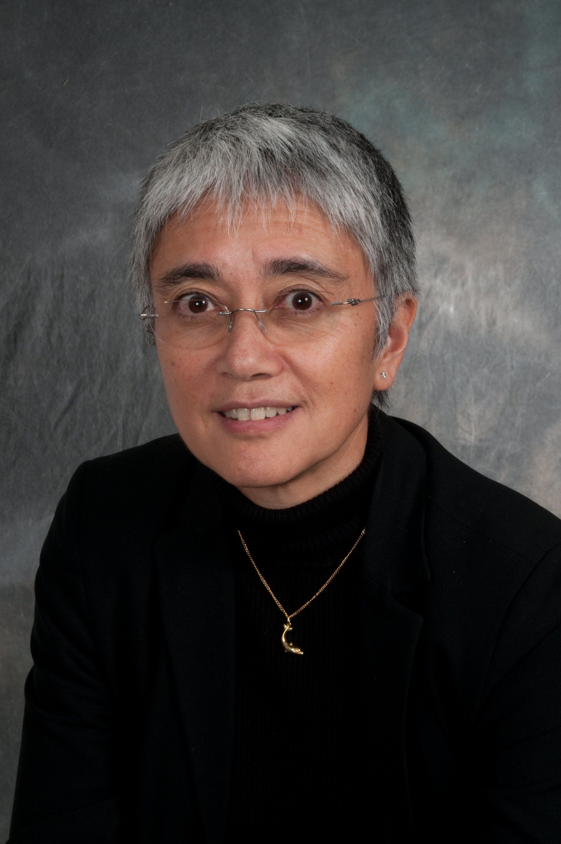 Lady head and shoulders studio portrait against a painted studio background