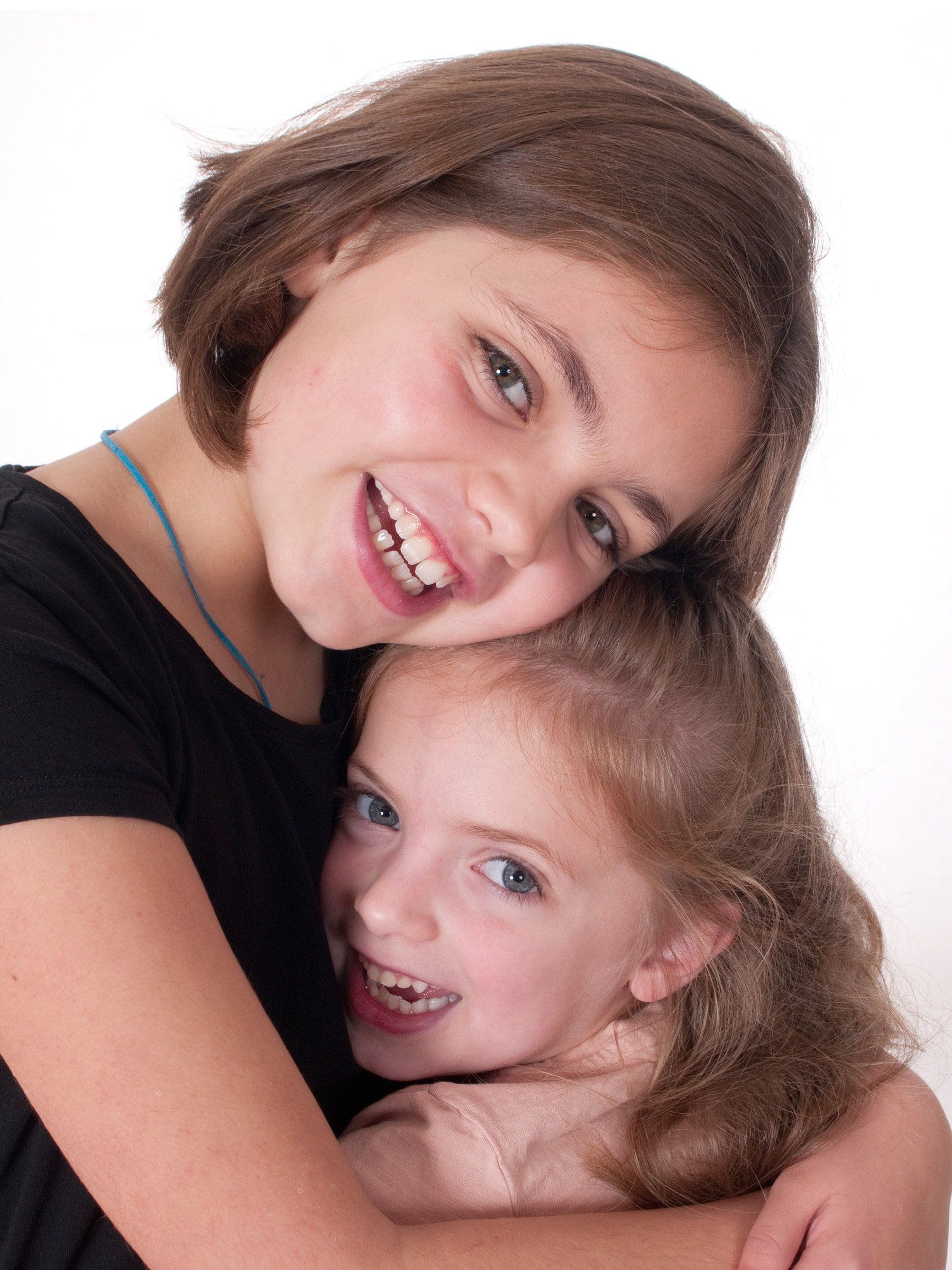 two sisters closeup hugging and smiling