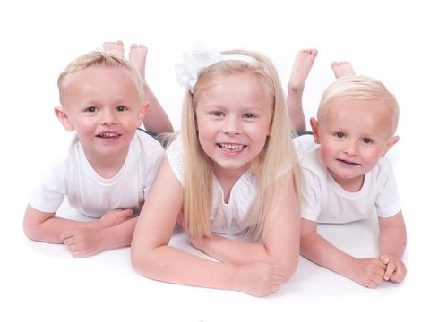 three children wearing white on a white background