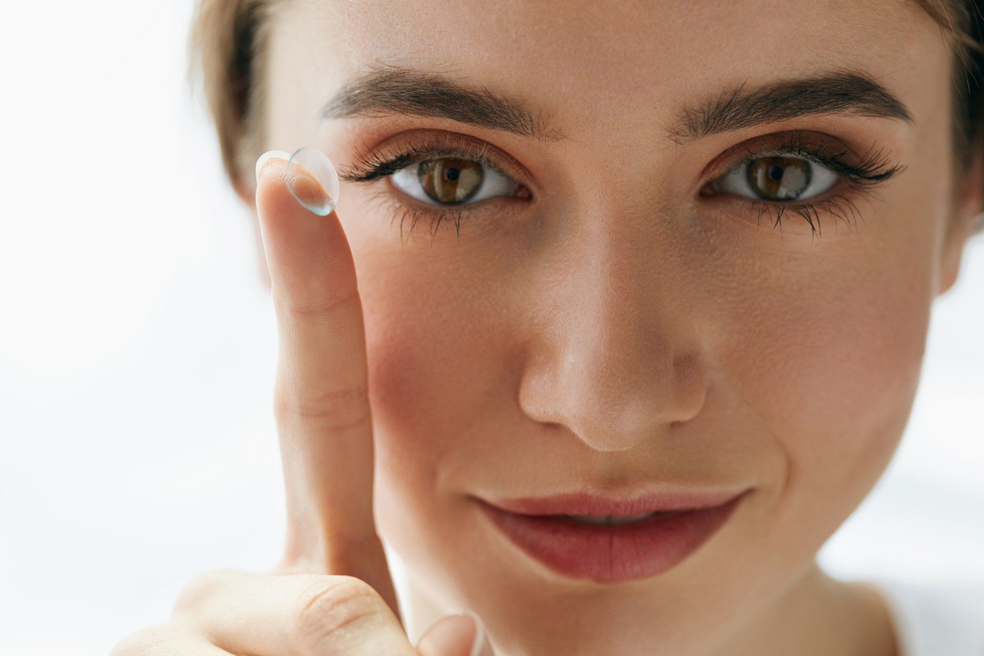 Frau mit Kontaktlinse am Finger