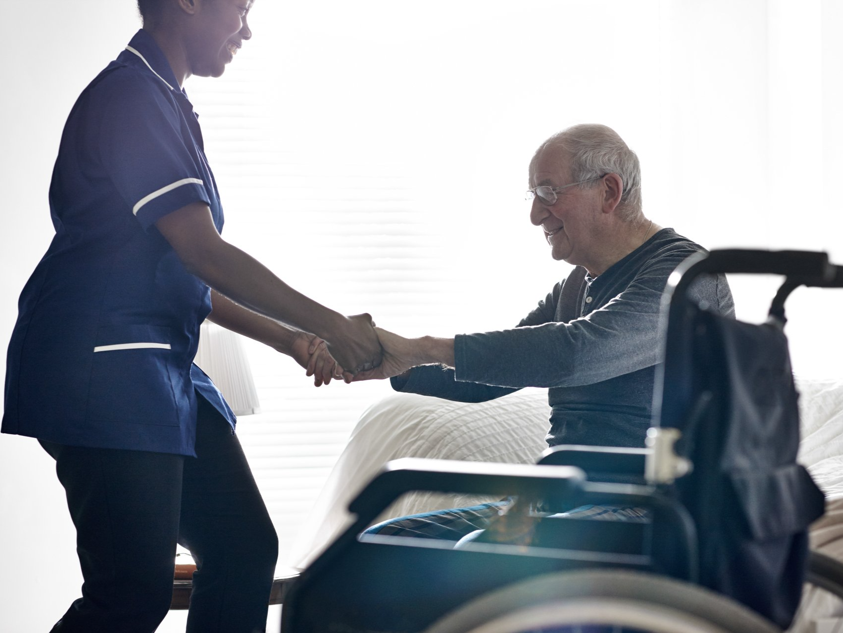 Carer assisting person to get out of wheelchair