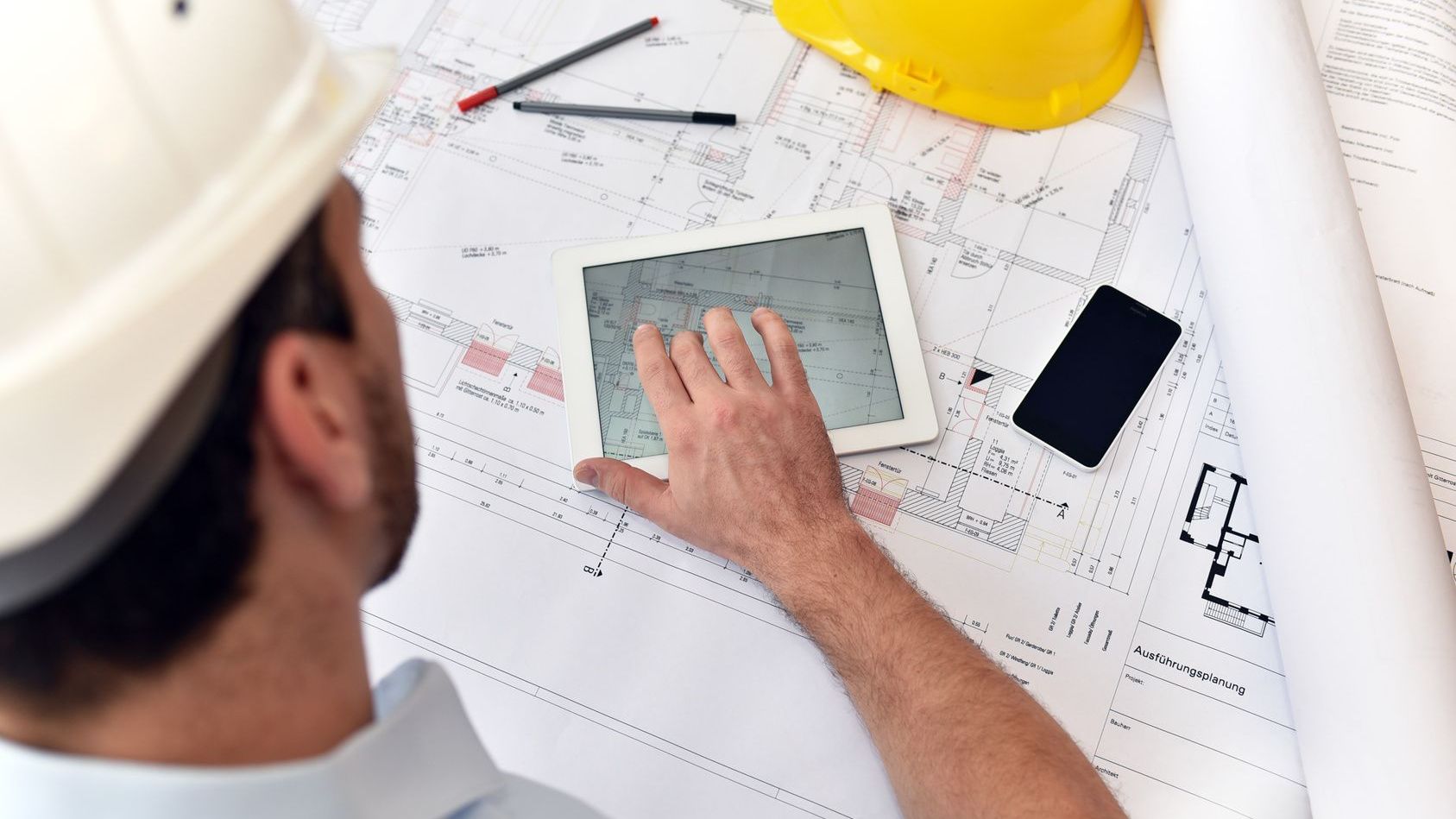 Brandschutzkonzepte Mann ließt Bauzeichnung