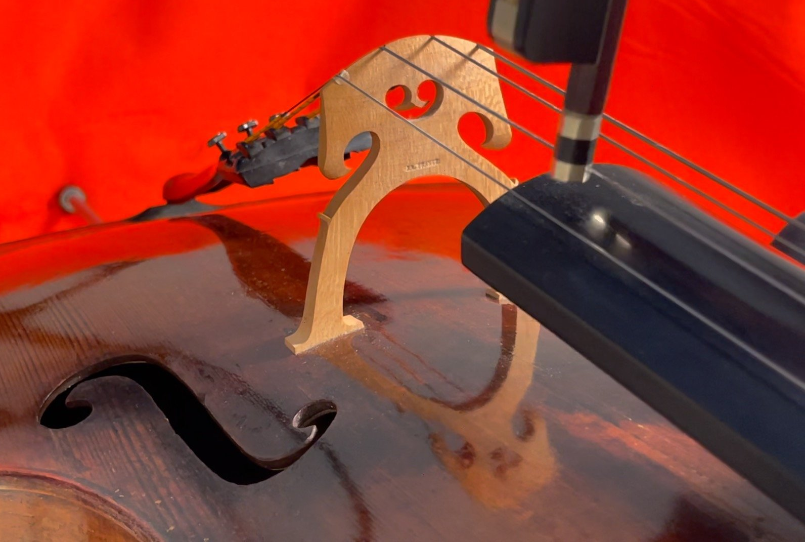 „Detailaufnahme eines Cellos vor orangem Hintergrund – visuelle Vorschau zur Sound Library des Projekts MOMENTUM von Sue Schlotte.“