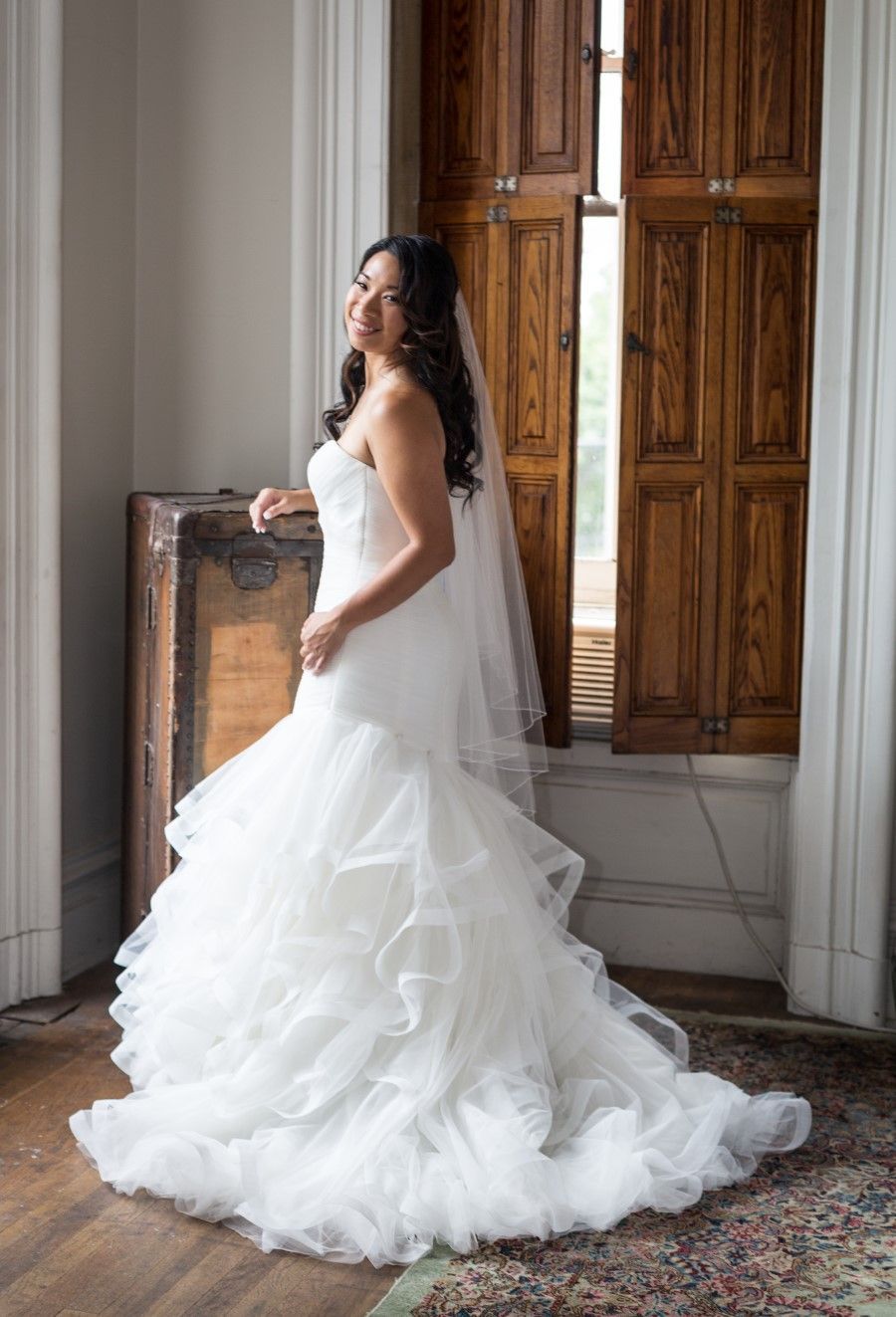 A happy bride radiates confidence after expert bridal alterations on her strapless mermaid wedding dress by MyAbishai.