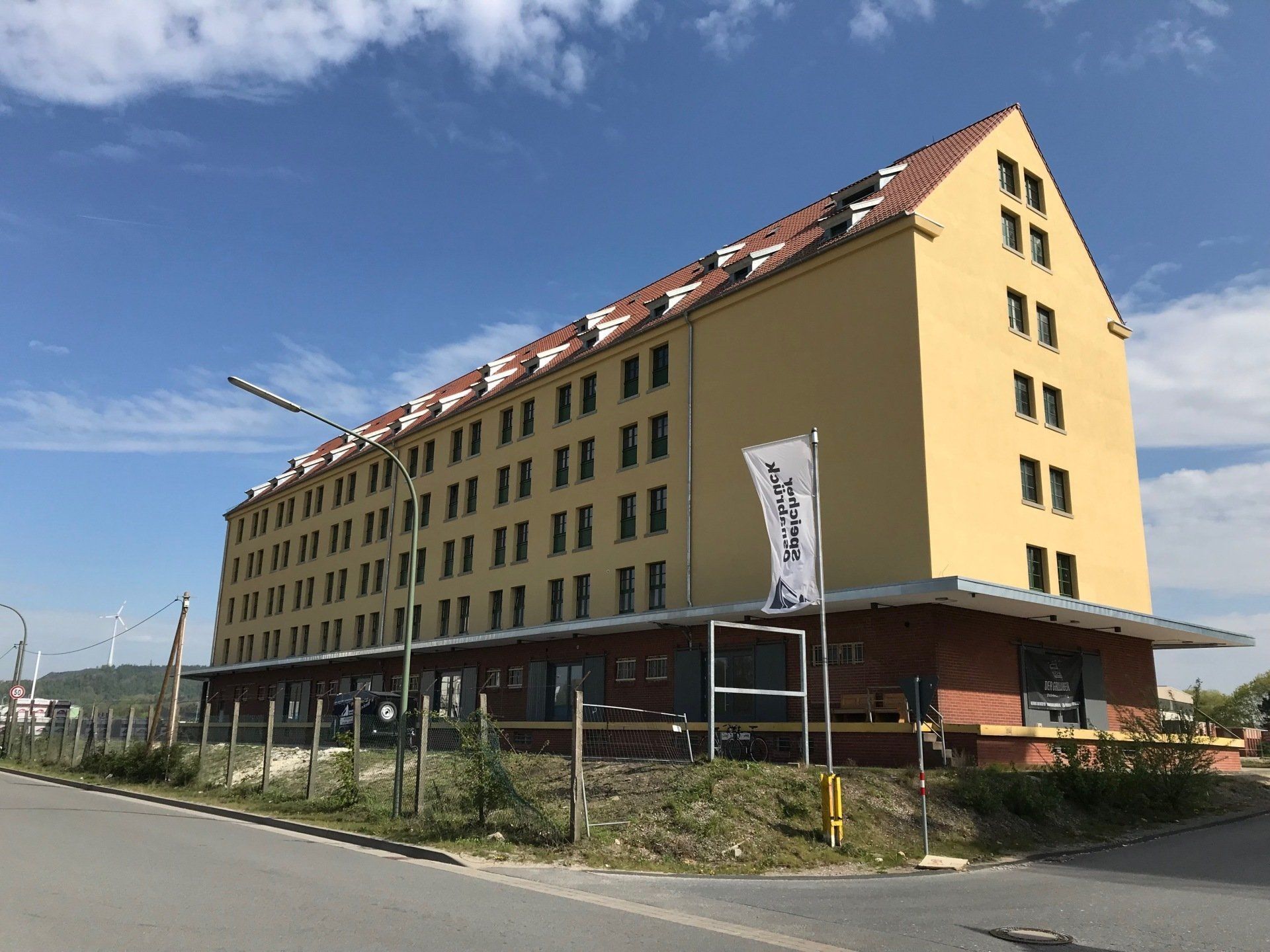 Ein großes gelbes Gebäude mit einer weißen Fahne, auf der