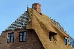 Ein halb gedecktes Dach symbolisiert den Angebotsvergleich für Dachdecker und Fenster.