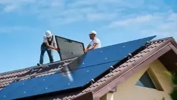 Zwei Solarteure installieren eine Solaranlage auf einem Dach.