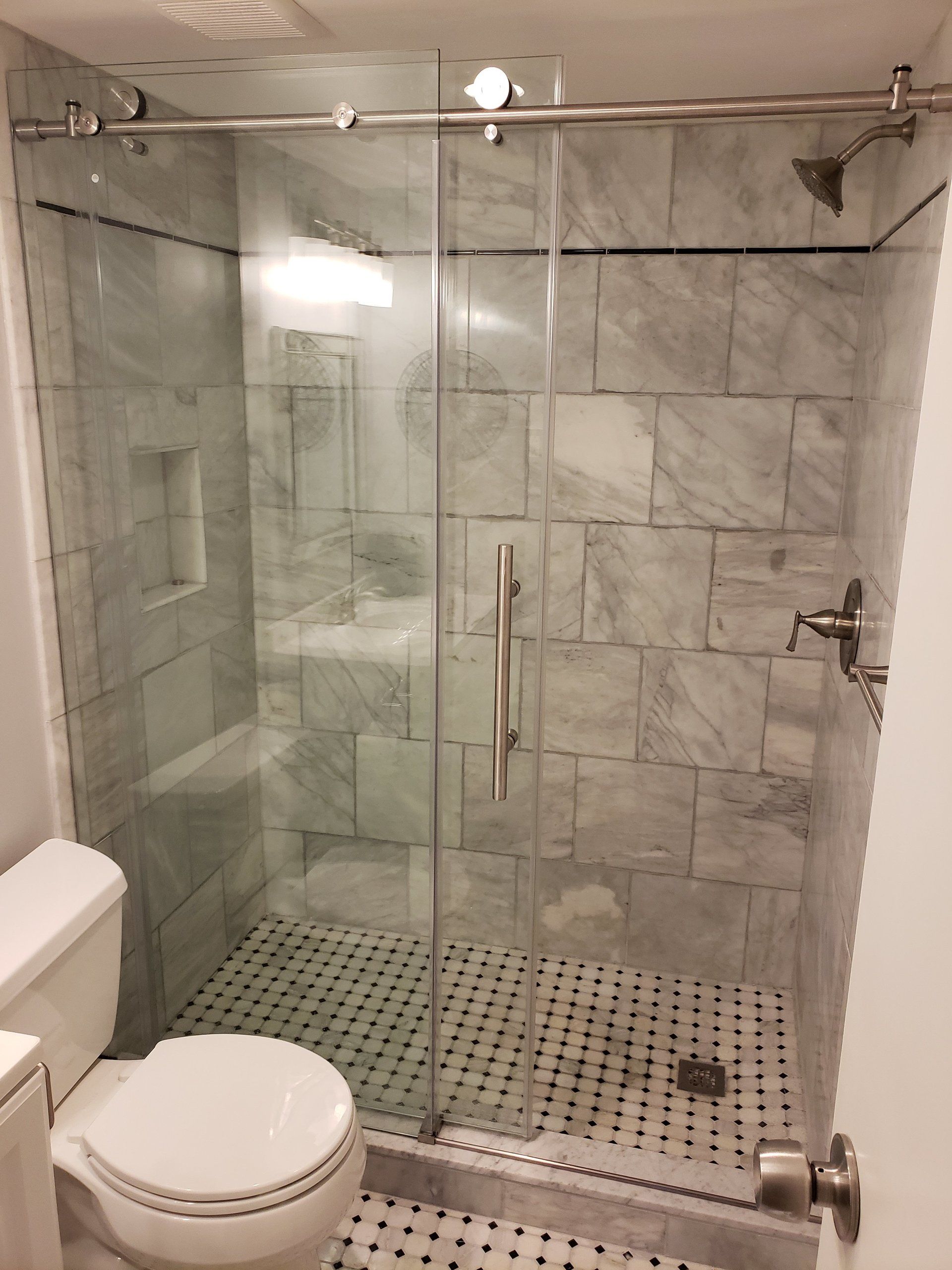 frameless sliding shower doors installed in granite and marble shower in Jenkintown bathroom remodel