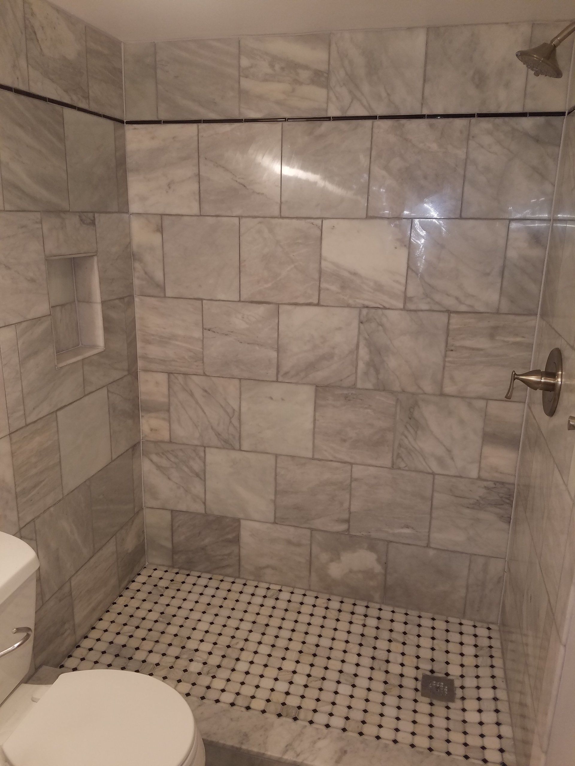 Bathroom remodel in Jenkintown with white black and gray marble and tile combination on shower floor and walls