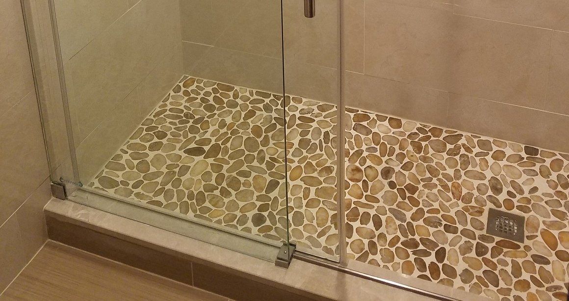 bathroom remodel in Abington with custom pebble shower floor tile installation and glass doors