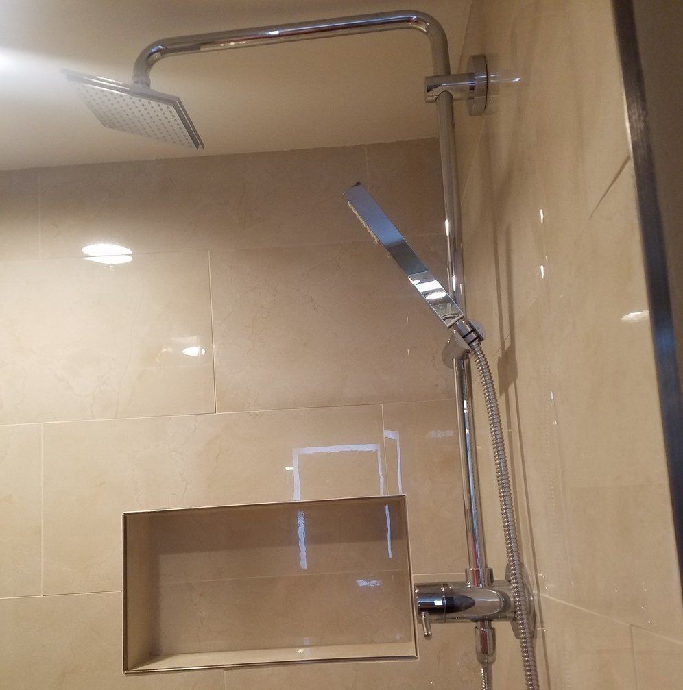 modern bathroom renovation in Elkins Park with rain shower head and shower niche in cream tile