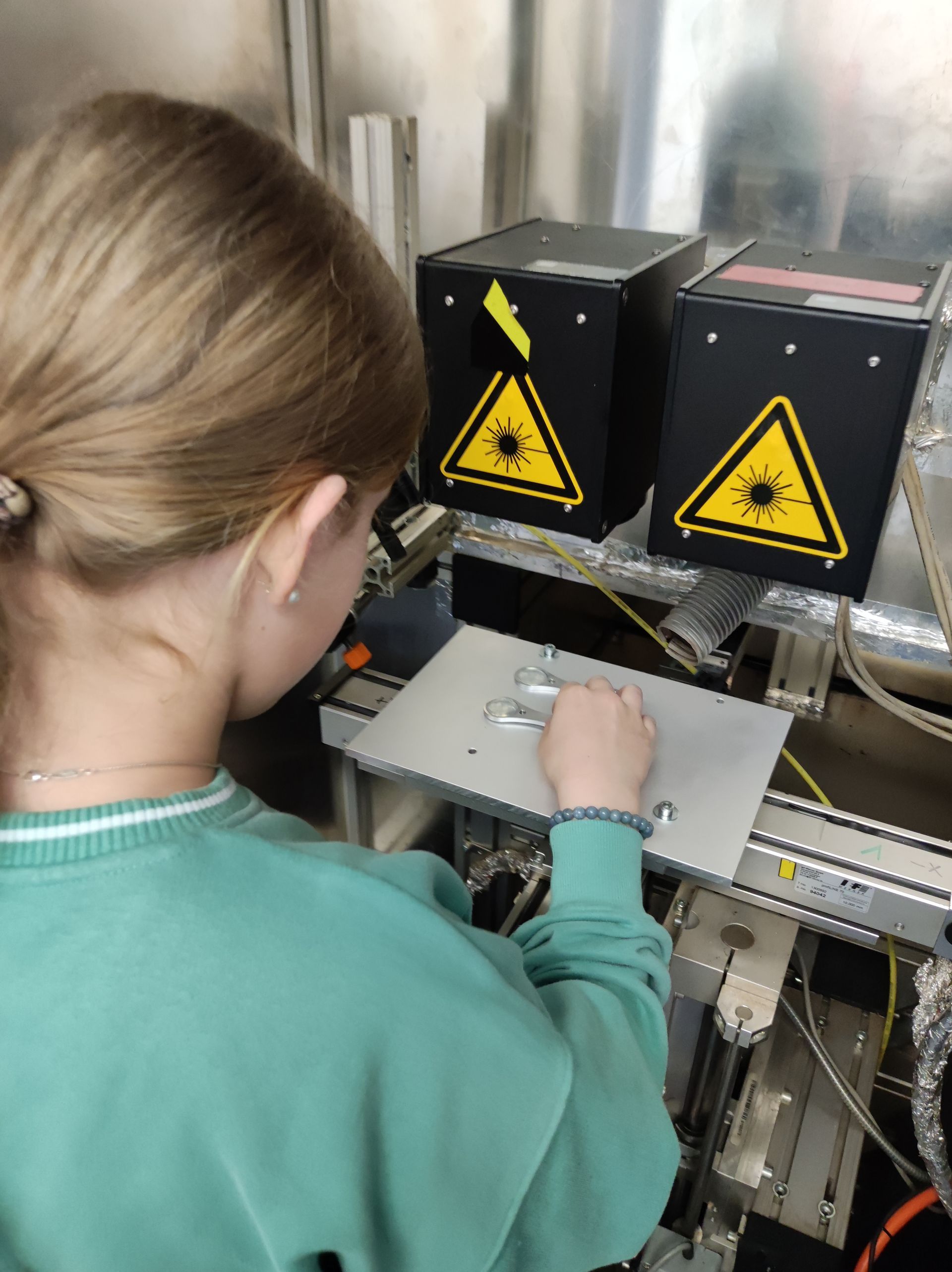 ein Mädchen legt etwas in eine Laseranlage ein