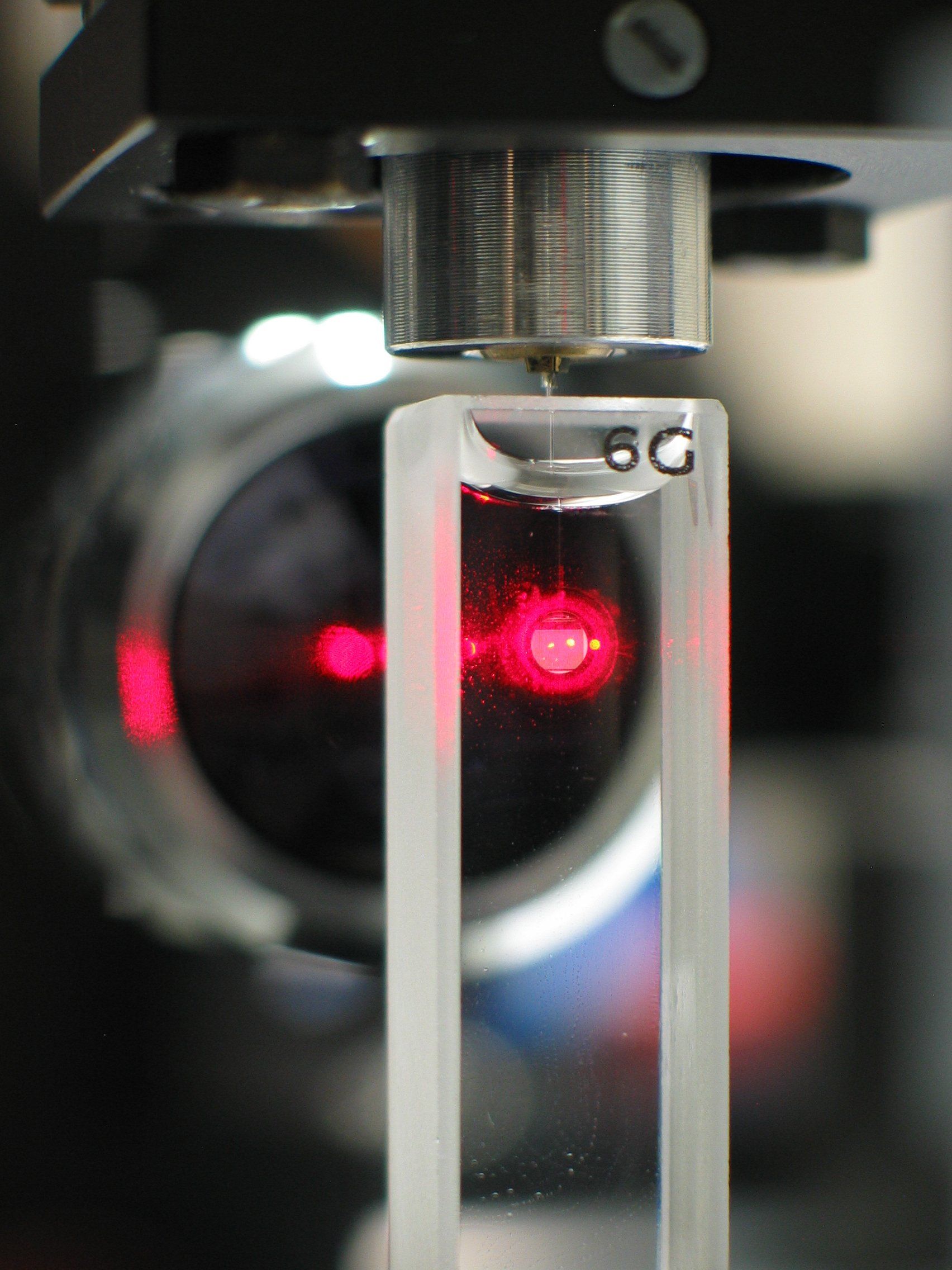 Das Foto zeigt eine optische Messung mit rotem Laserstrahl.