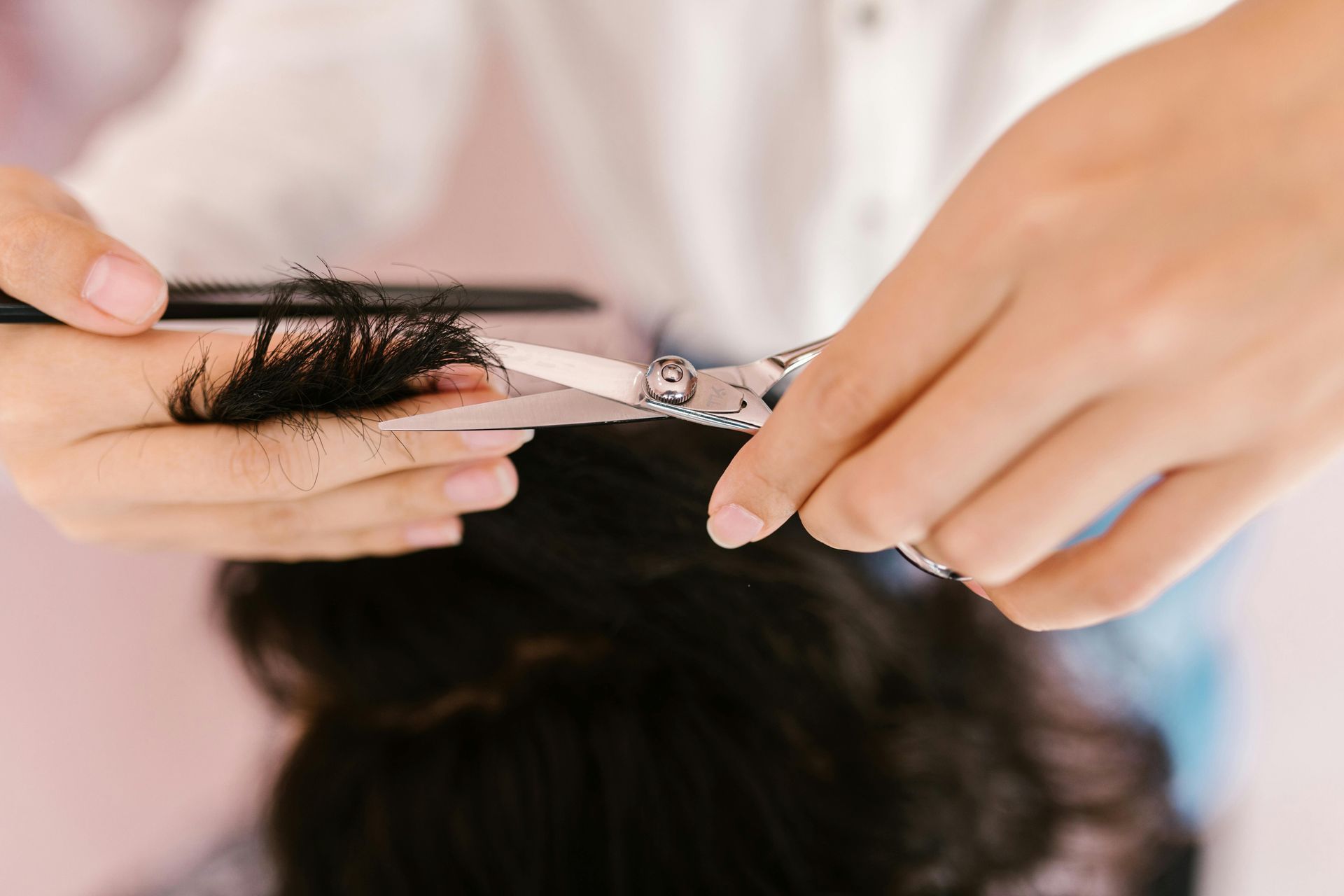 Hairstylist cutting hair dry to allow for more flow within the hair.