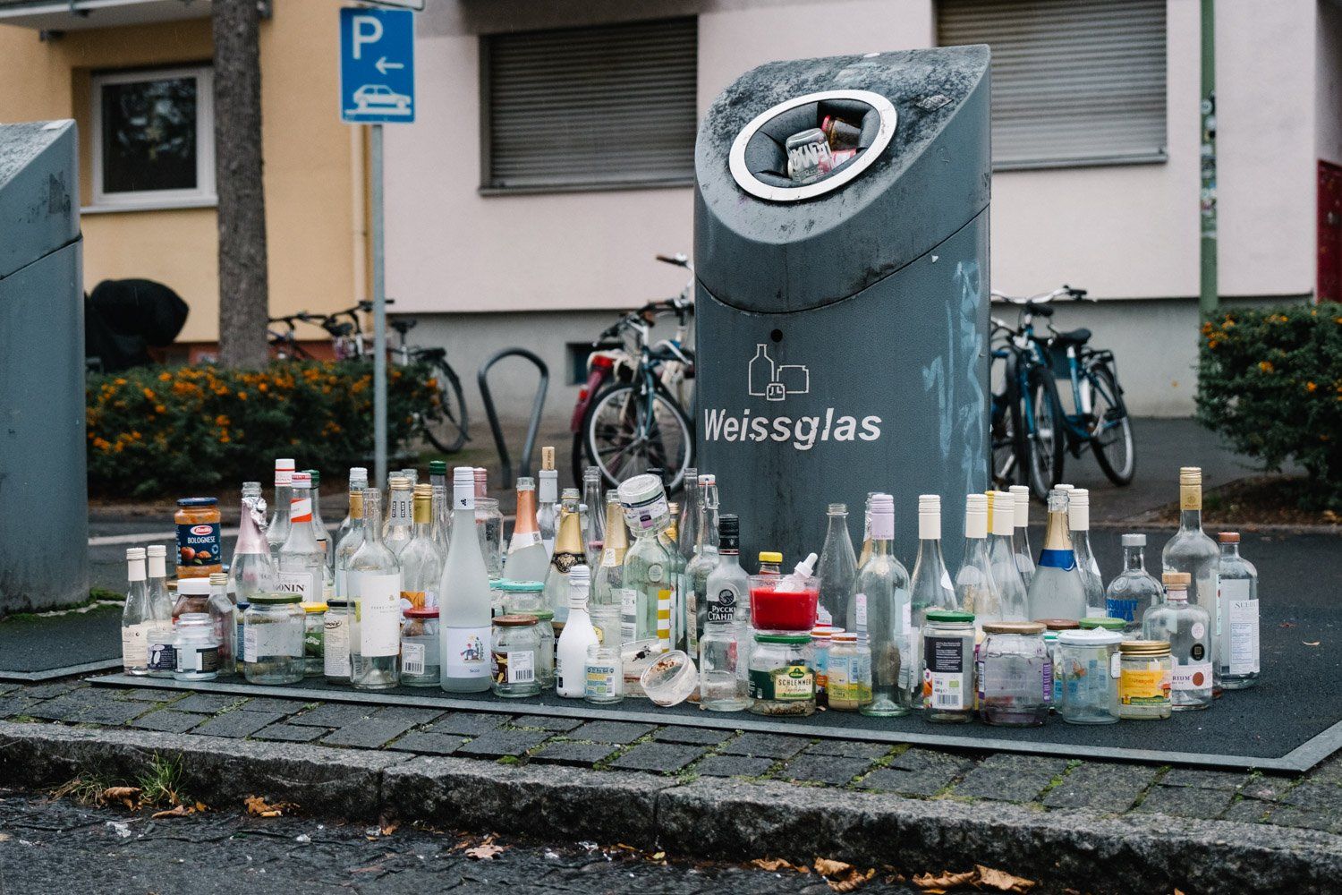 Altglas-Container mit einer Menge leerer Flaschen