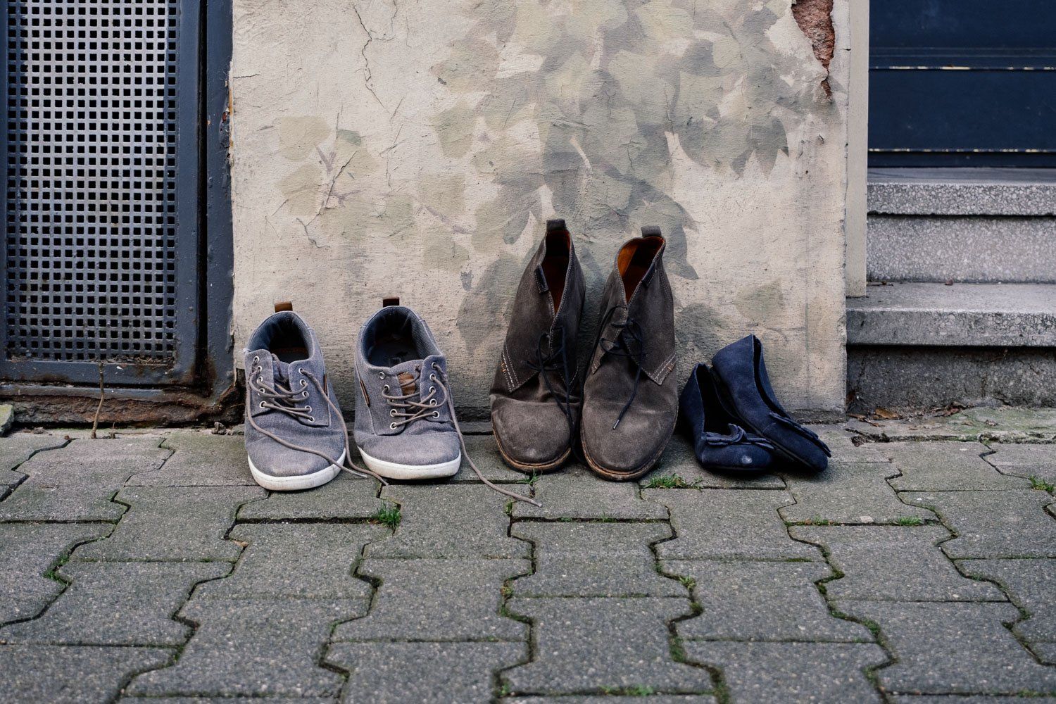 Drei Paar Schuhe stehen verlassen auf der Straße