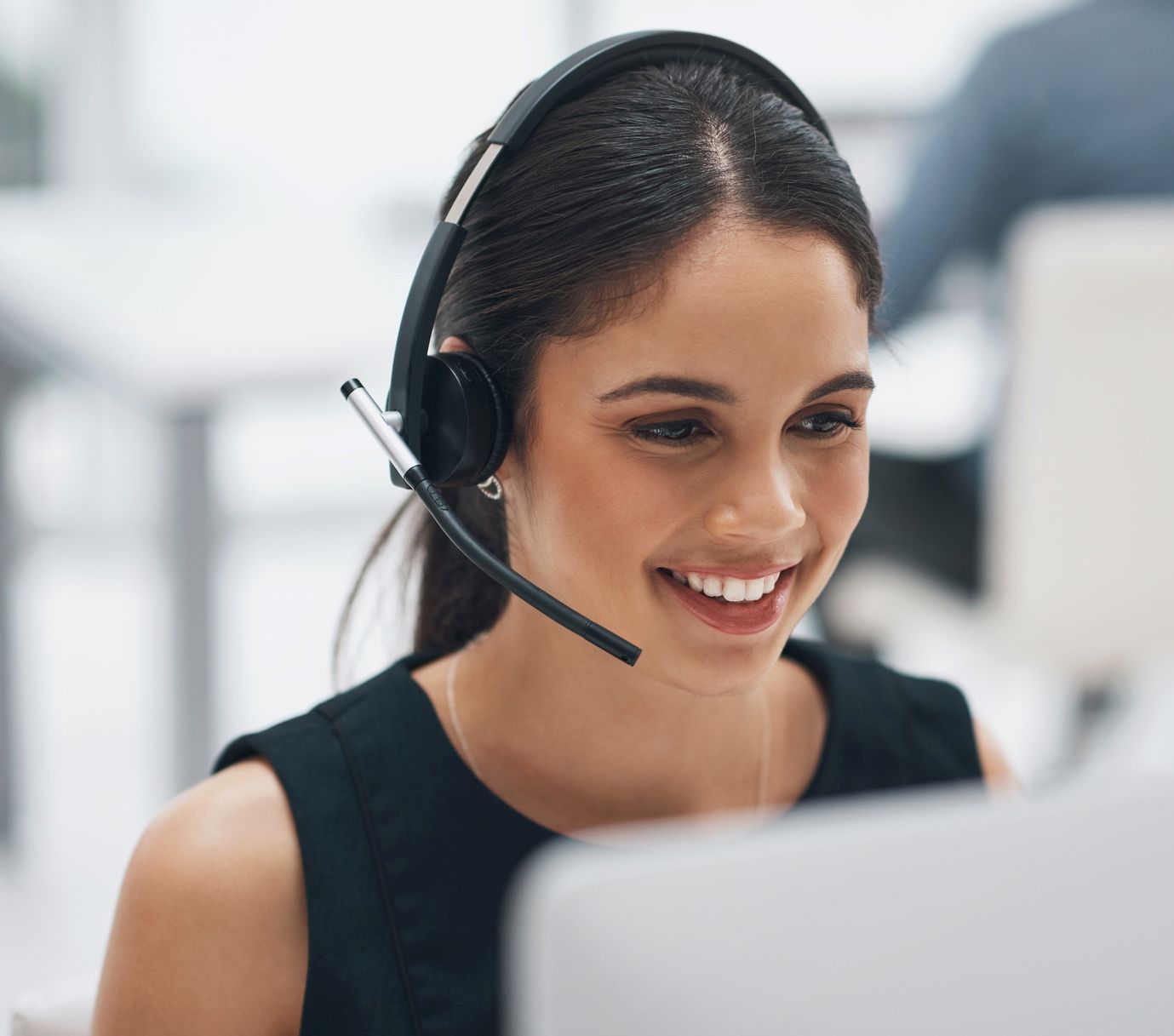 Frau vom Callcenter schaut auf Monitor.