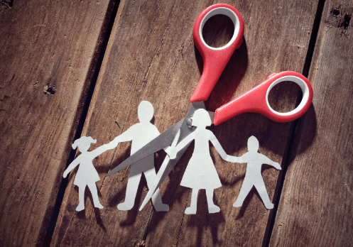 Familia hecha de papel y unas tijeras cortandola por la mitad