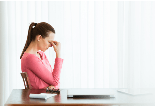 Mujer tocándose la frente con gesto de preocupación
