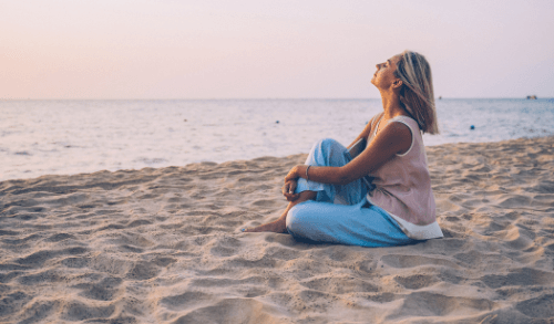 Mujer respirando en la playa