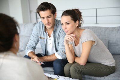 Evaluación adultos Dos adultos sentados en un sofá escuchando a su terapeuta