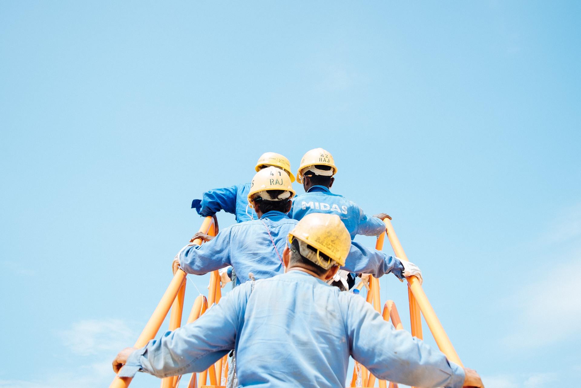 Trabajadores de la construcción subiendo un andamio