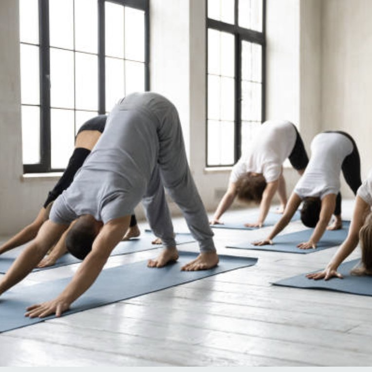 Yogapose heraufschauender Hund auf einer Yogamatte vor einer Betonwand.