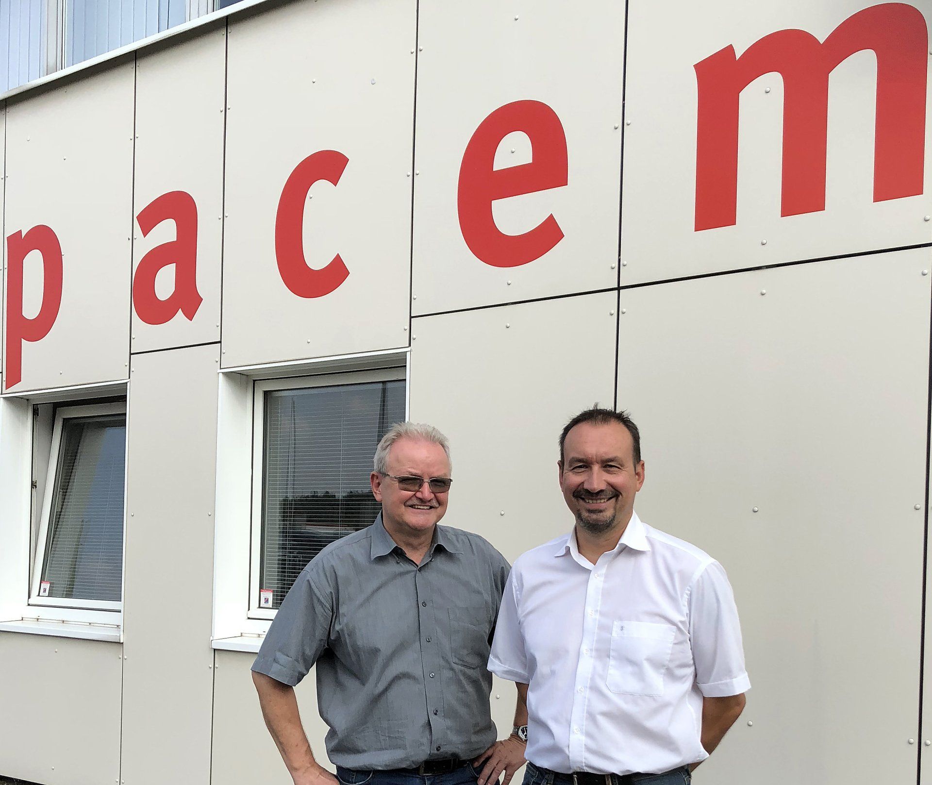 Druckpartner Die 2 Vorgesetzten vor dem Pacem-Druck-Gebäude. Glücklich und lächelnd.