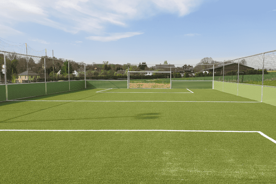 Soccercourt mit grünen Banden, einem Tor und grünem Rasen