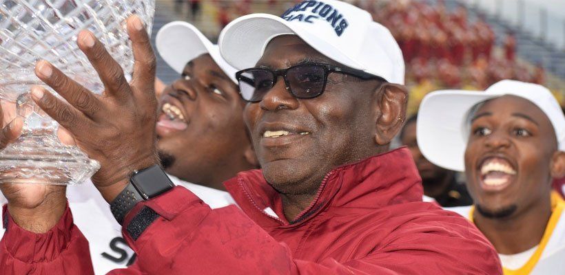 Tuskegee Coach Willie Slater holds the Southern Intercollegiate Athletic Conference championship trophy.