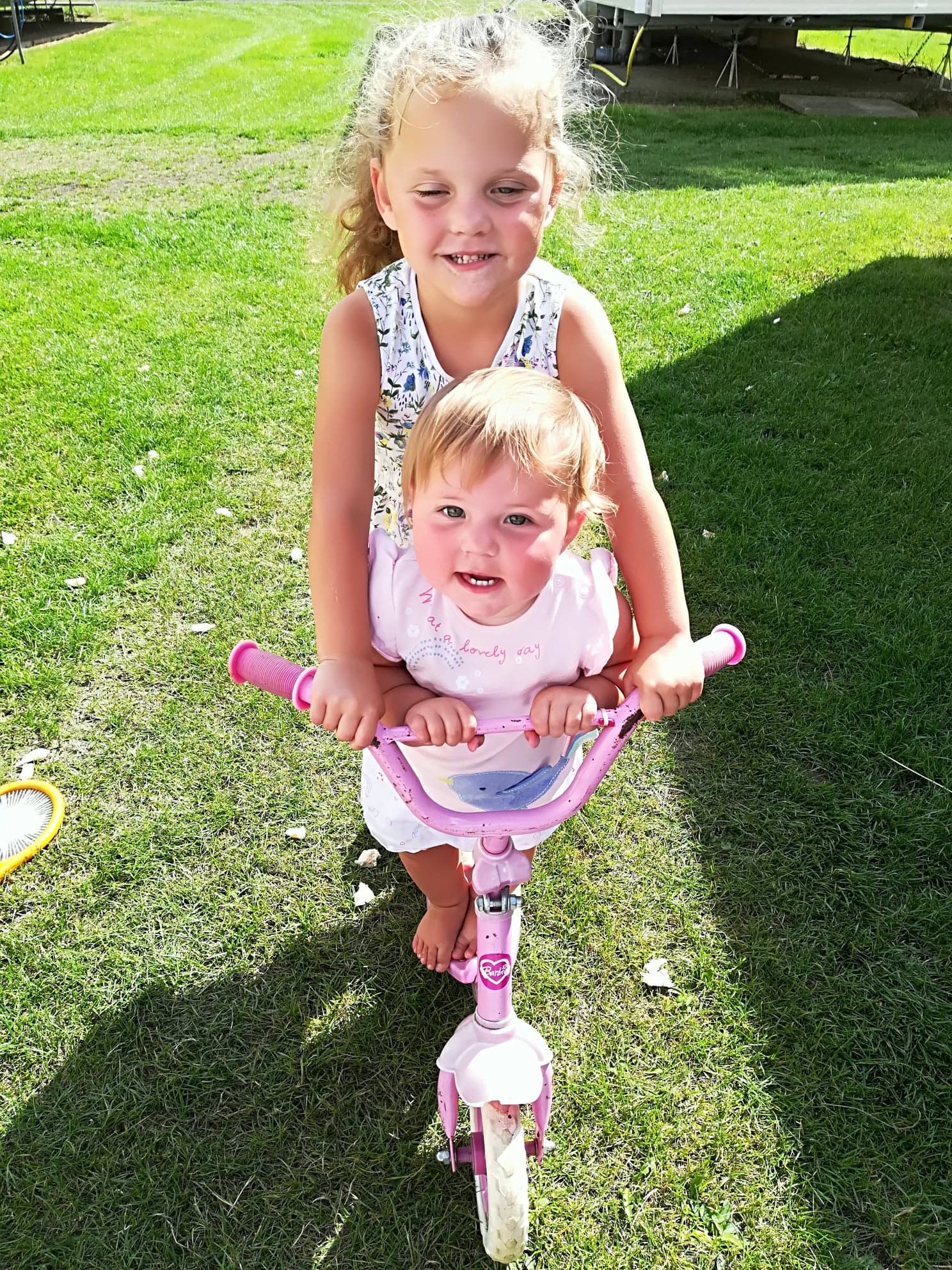 Skye and Ava riding a scooter from family album