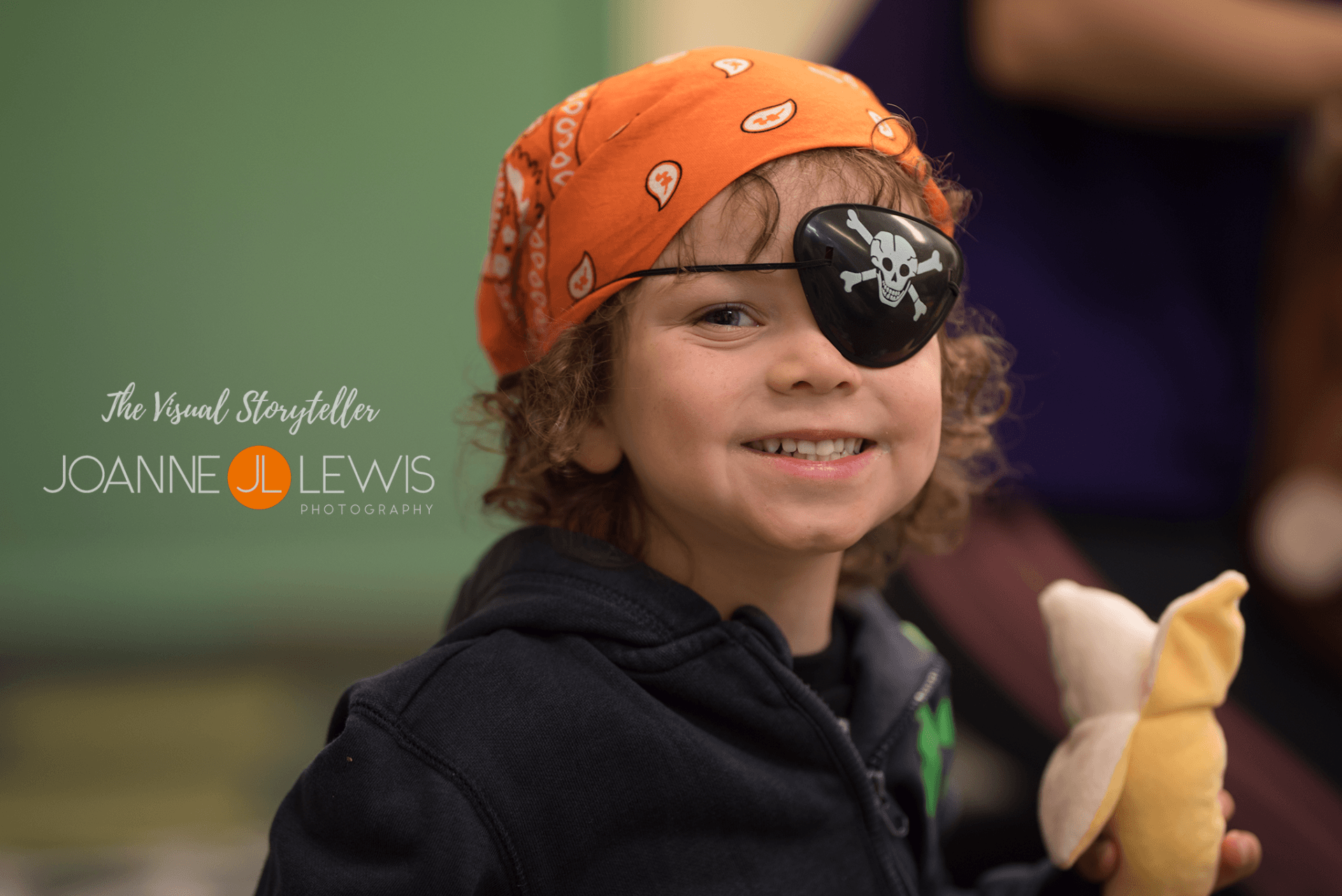 Little pirate dress up in bandana hat and patch smiling for a photograph
