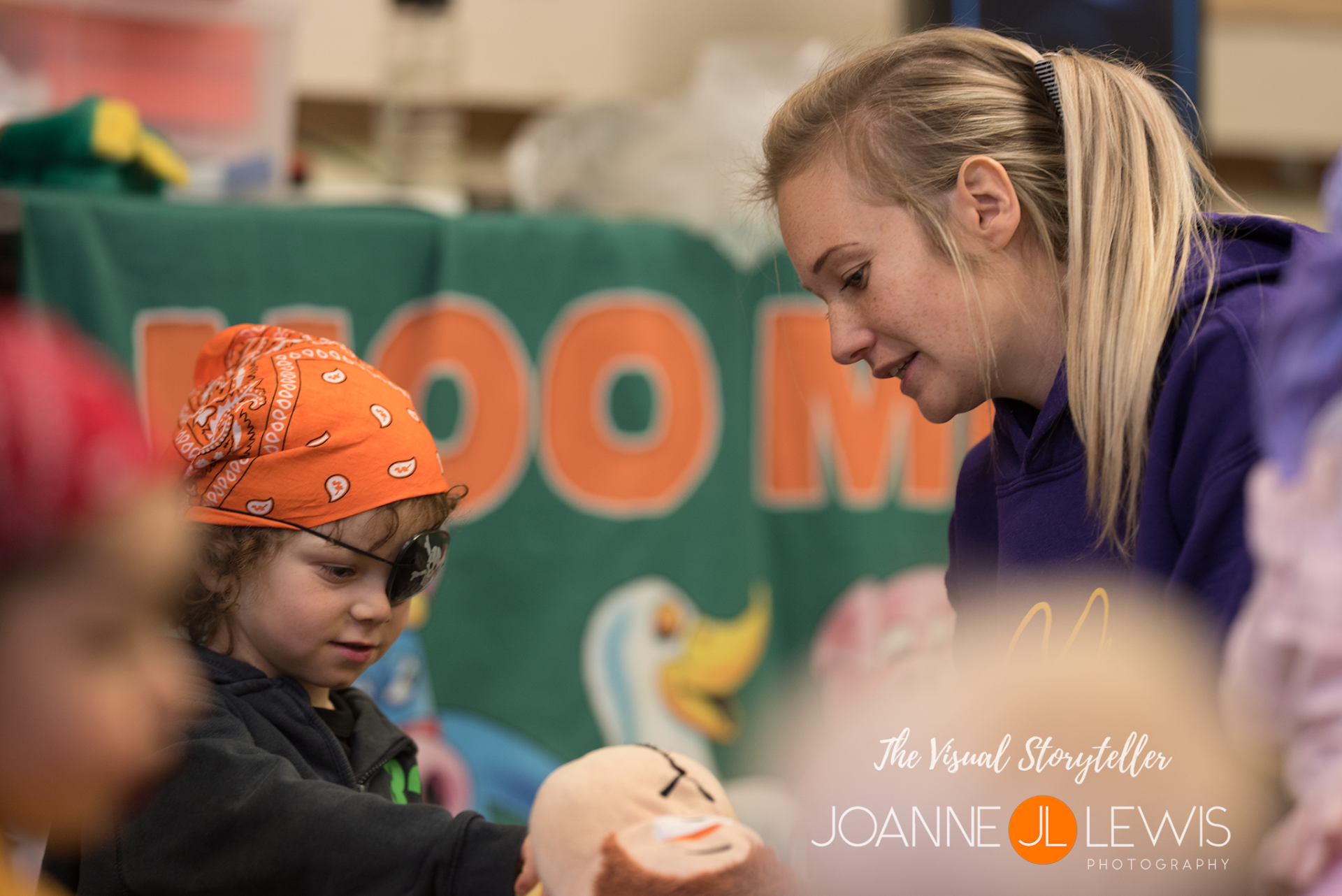 Photograph of Abi from Hertford moo music with little boy feeding bananas to the toy monkey puppet