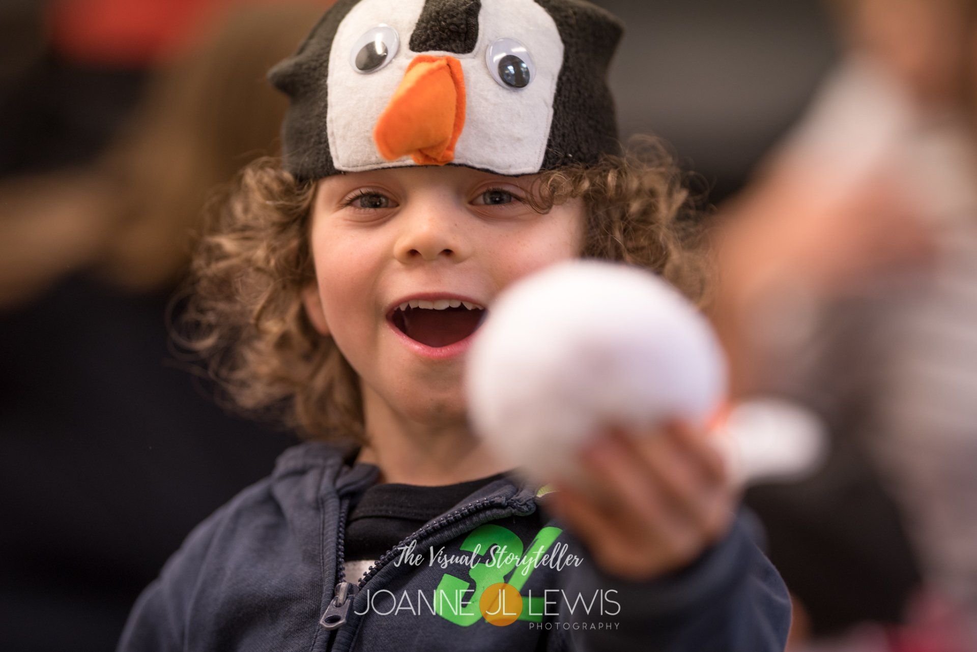 Boy dressed up as penguin having fun with a snowball at Hertford and Ware Music Class