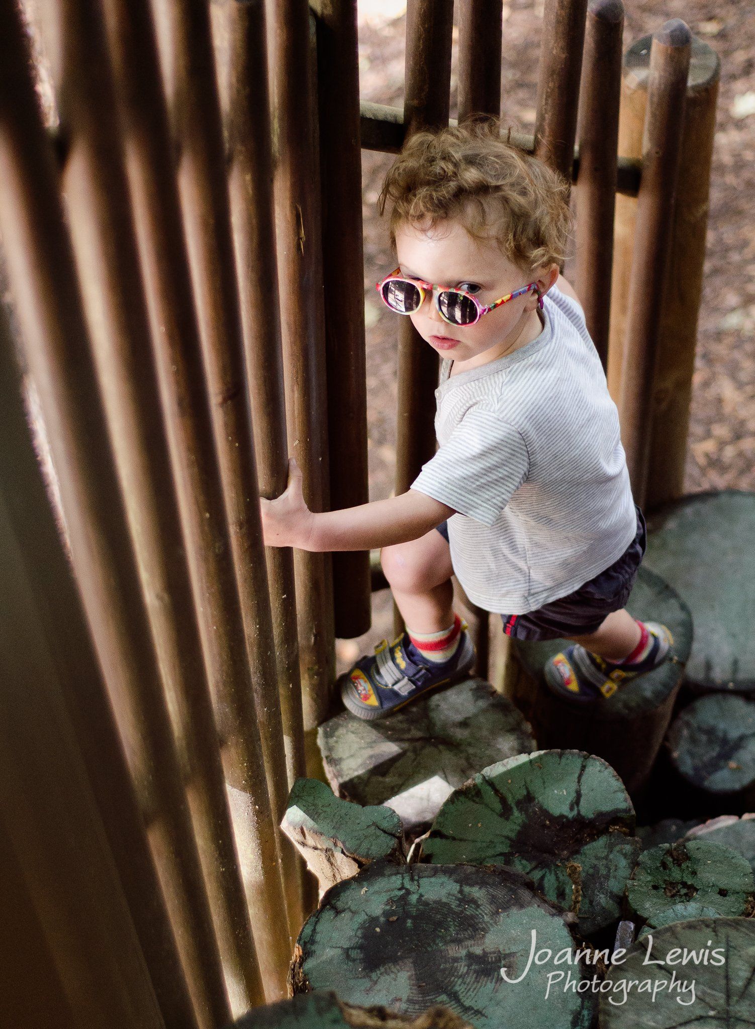 Boy climbing on stepping stumps at Bewilderwood