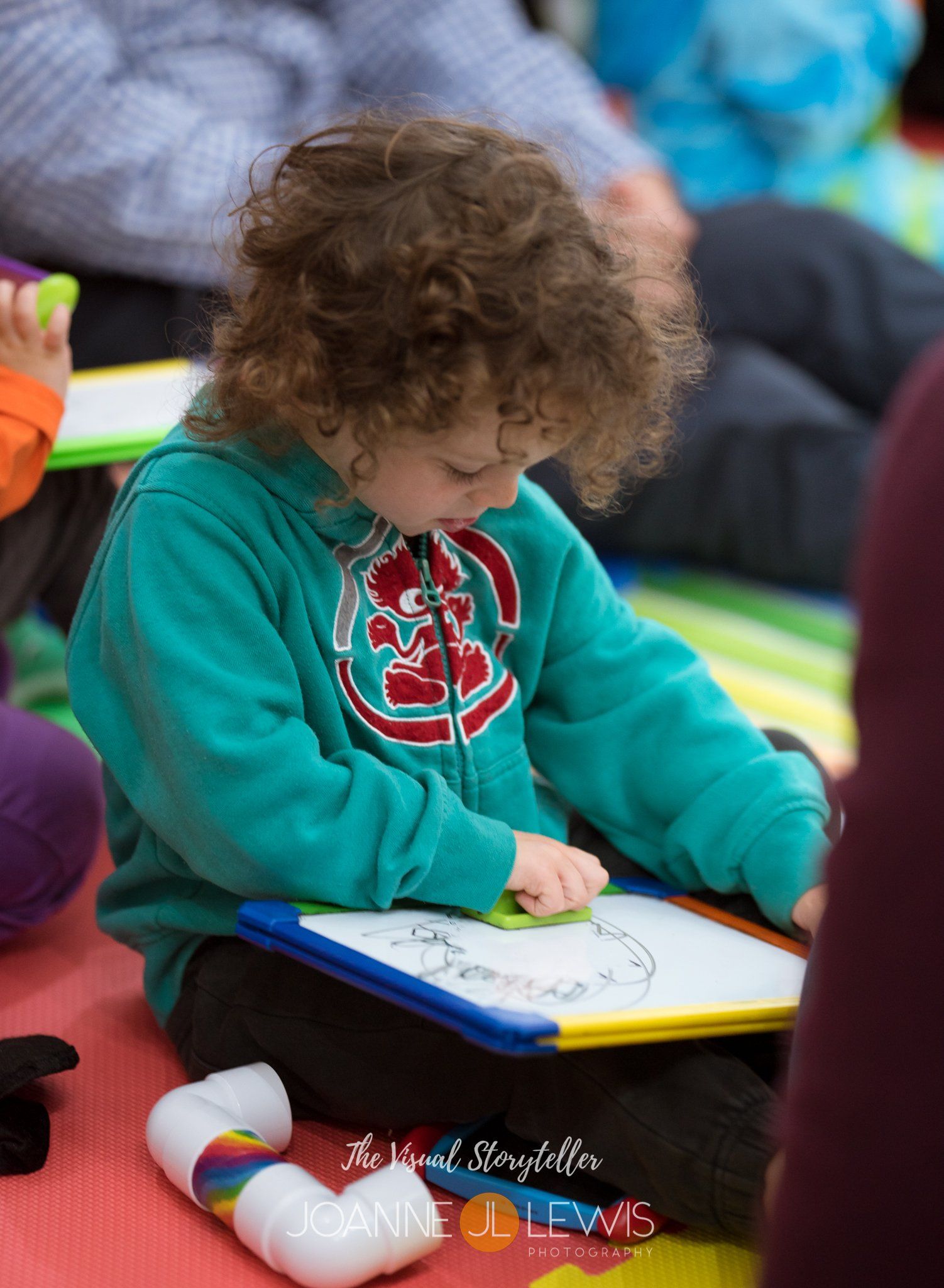 Young boy drawing on whiteboard on his lap