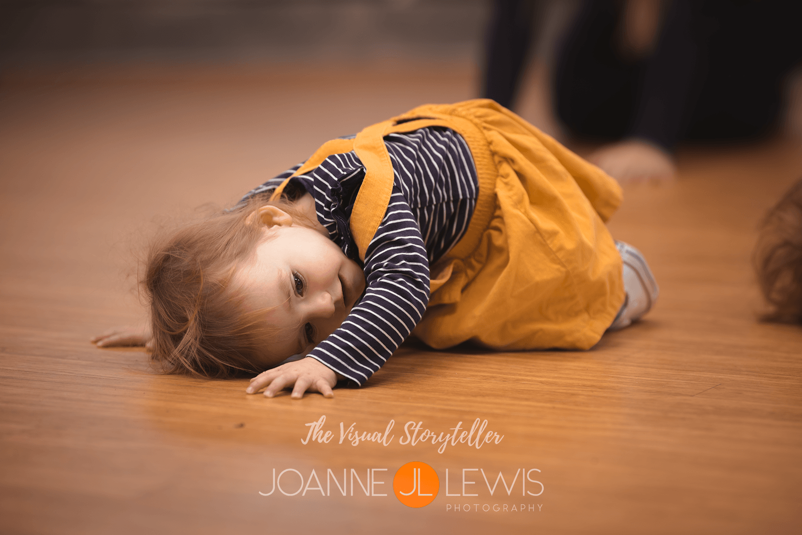 Little girl lying down wearing pretty yellow dress