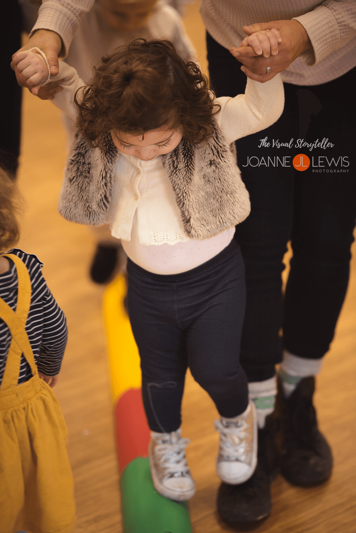 little girls walking on balance beam at toddler group