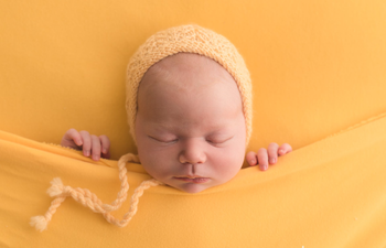 Newborn baby on yellow blanket photoshoot in Hertfordshire