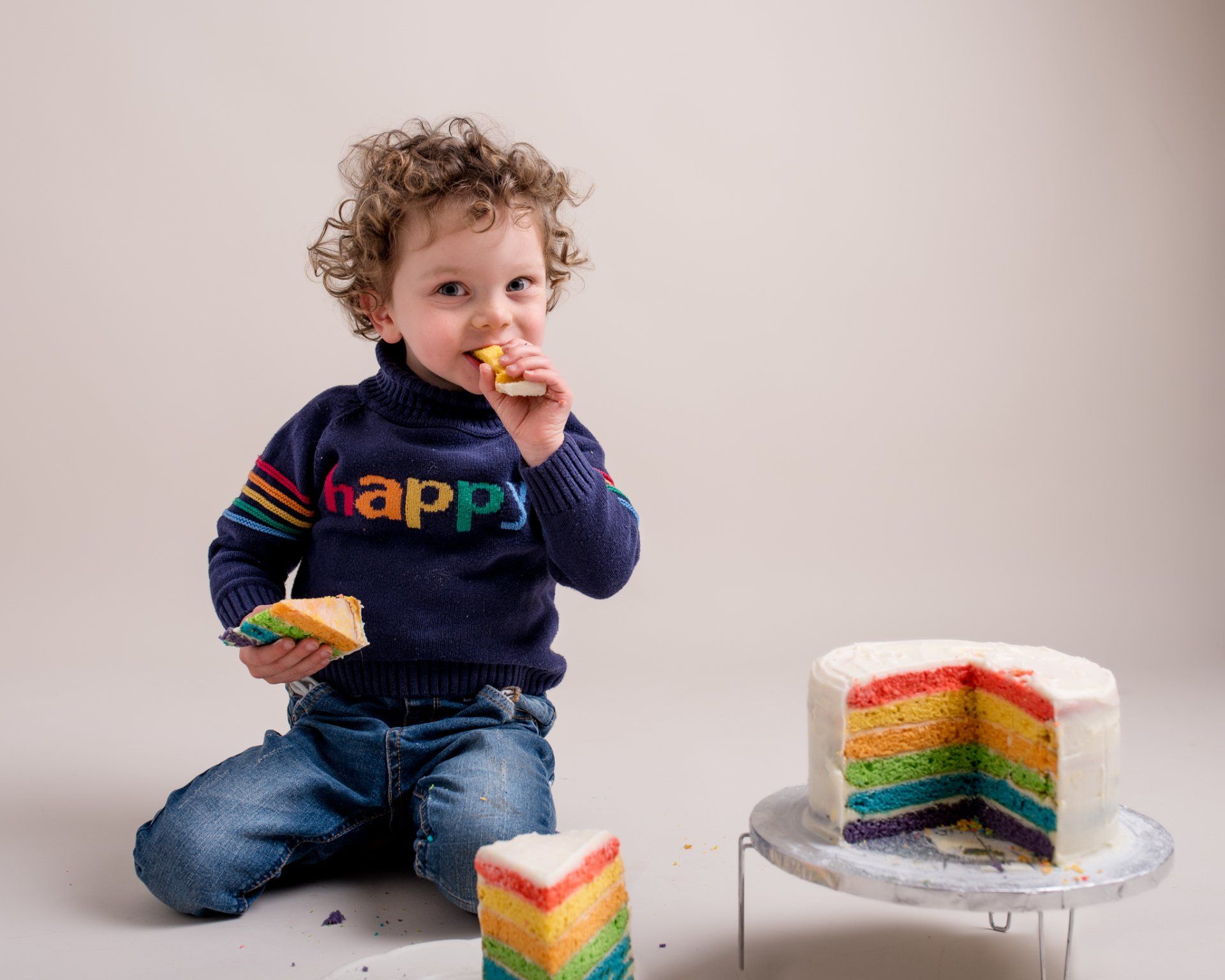 Cake smash. Little boy waring a HAPPY jumper for 3ed birthday photoshoot